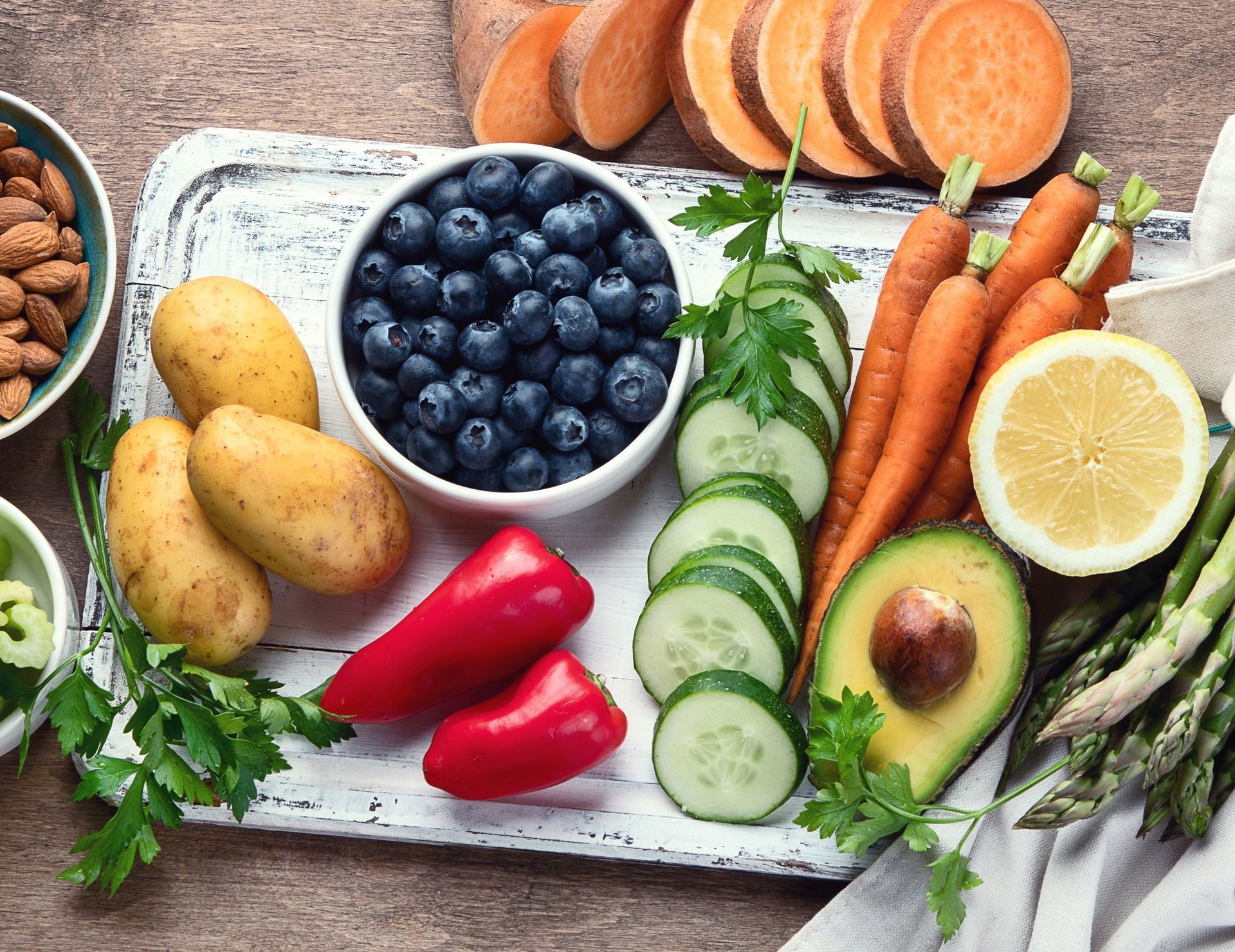 Assorted fresh fruits and vegetables on a wooden table.
