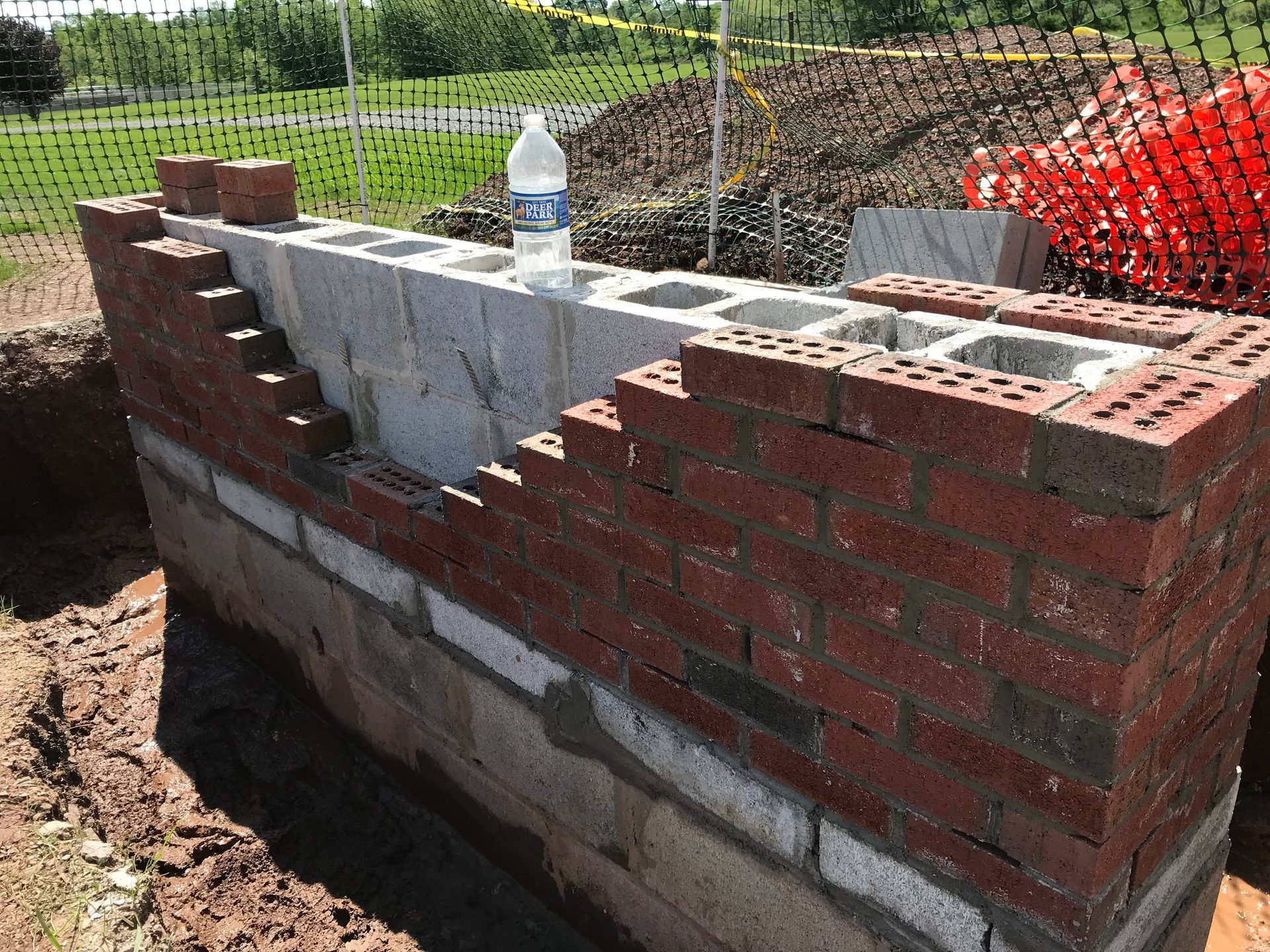 Brick wall with varying shades of brown and dark gray mortar.