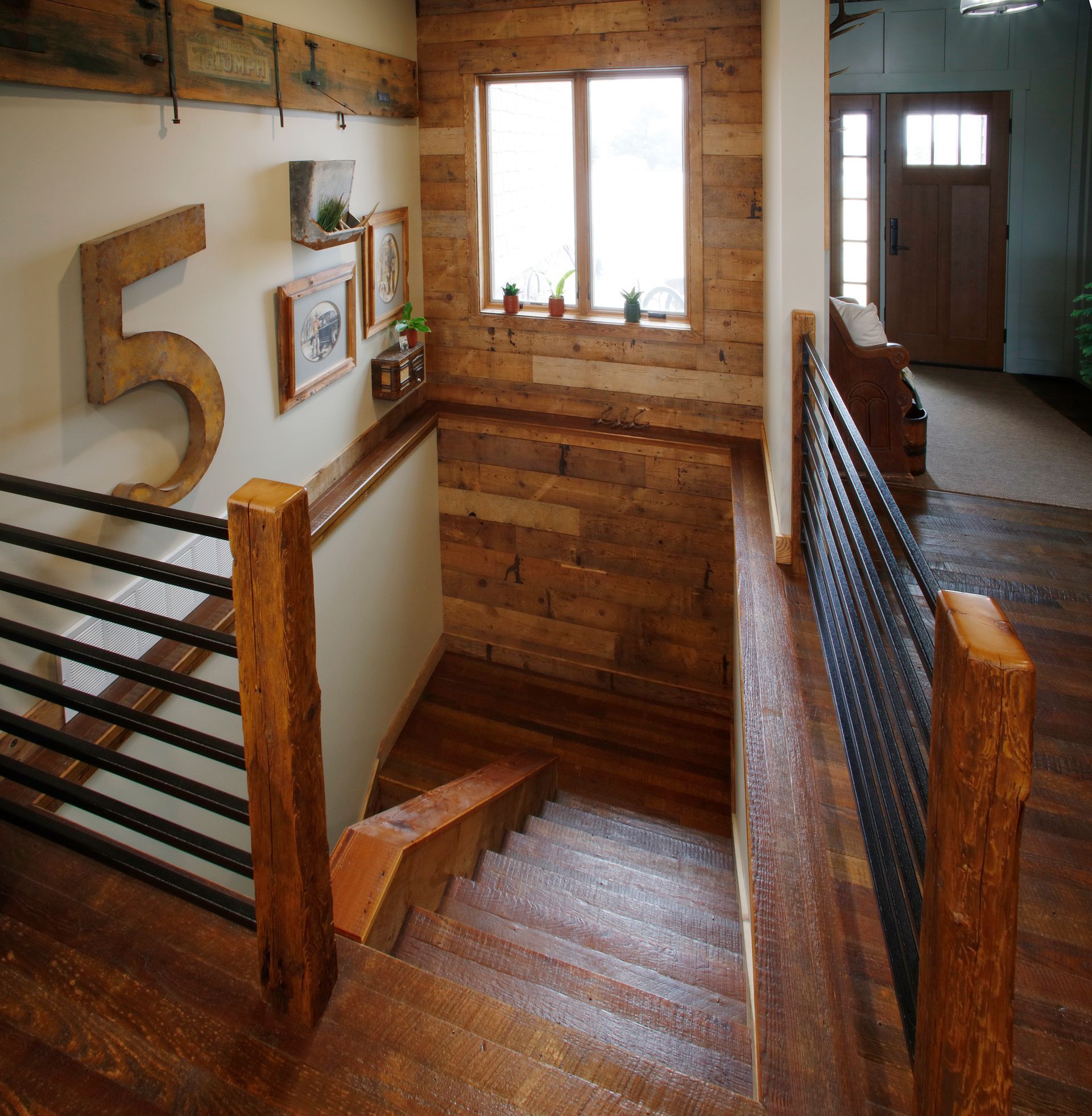 Wooden staircase leading down into a long, narrow room with wood-paneled walls.