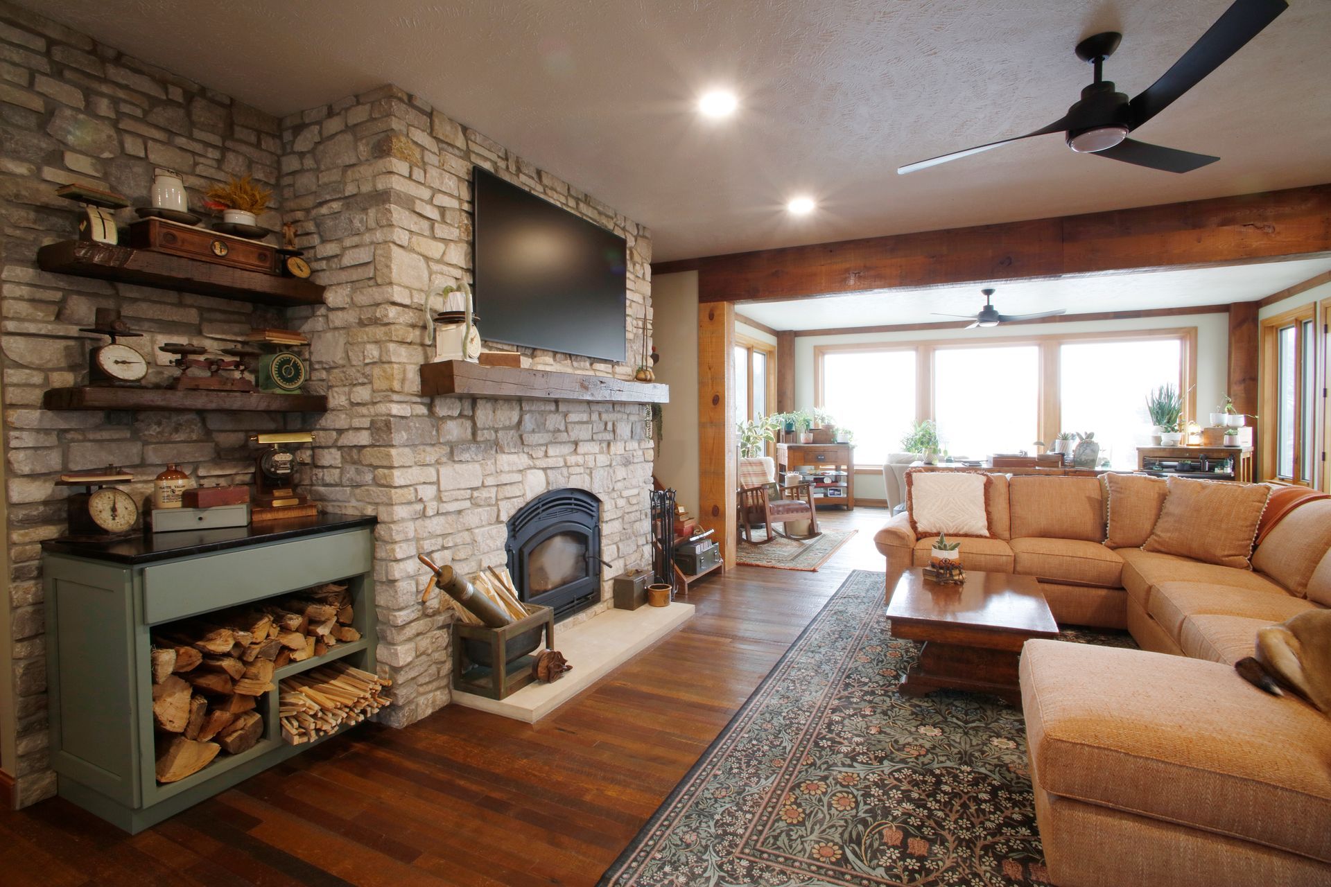 Living room with industrial fireplace, two brown recliners, and a red rug on a concrete floor.