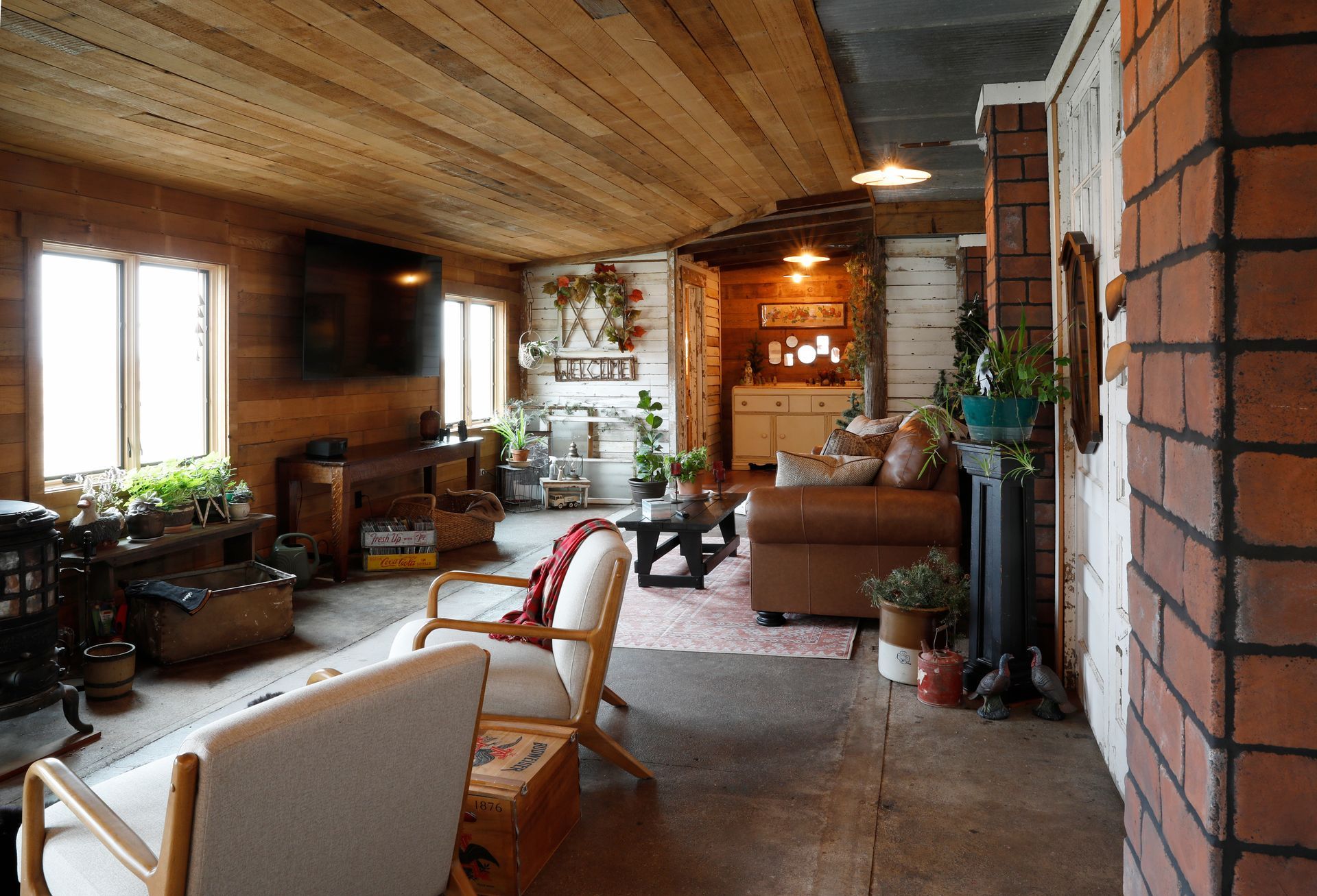 Interior of a rustic barn with wooden beams, red walls, chandelier, and a decorative windmill.