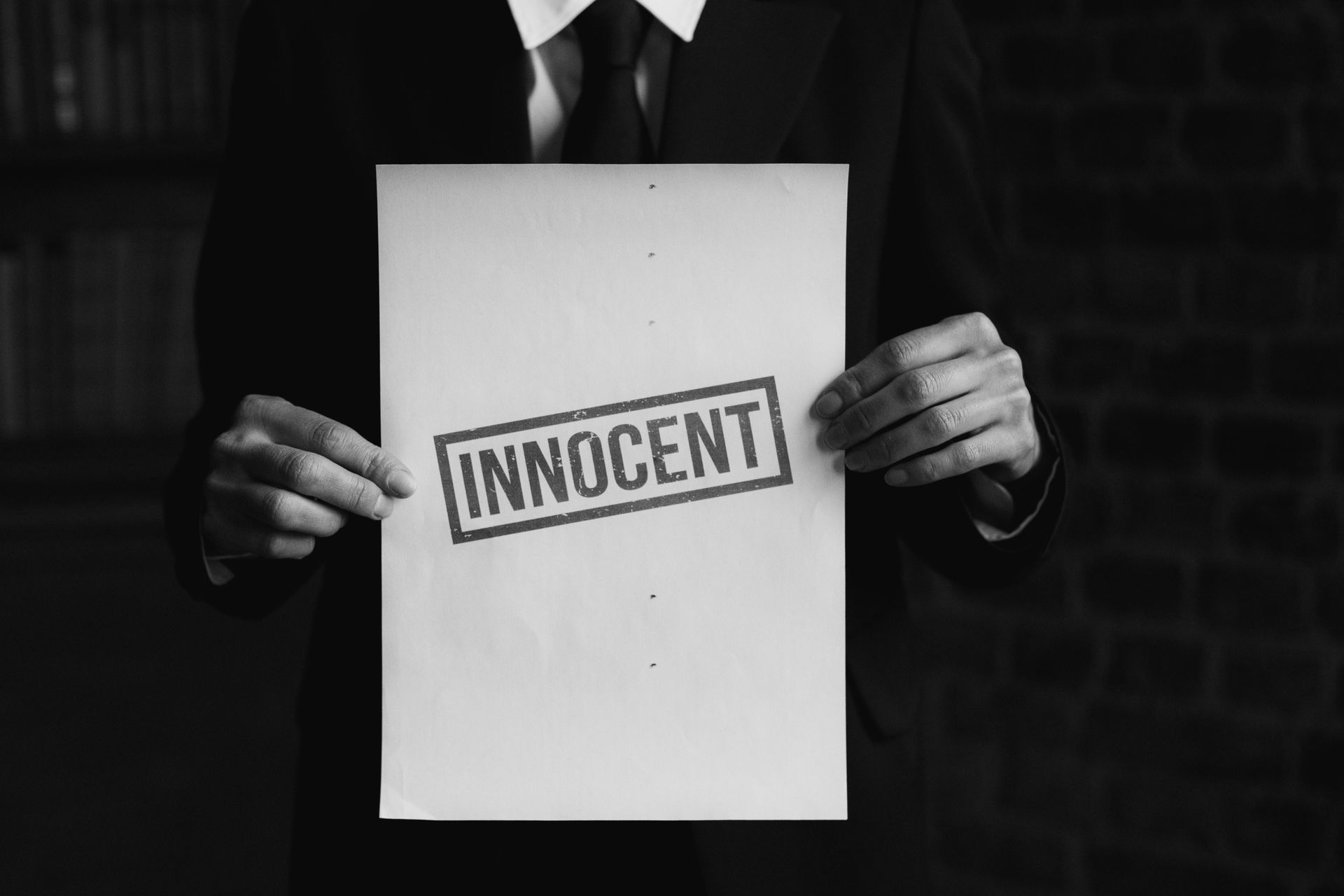 Person in suit holding a paper with 