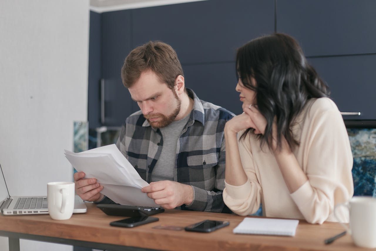 A couple sitting at the table, looking at documents