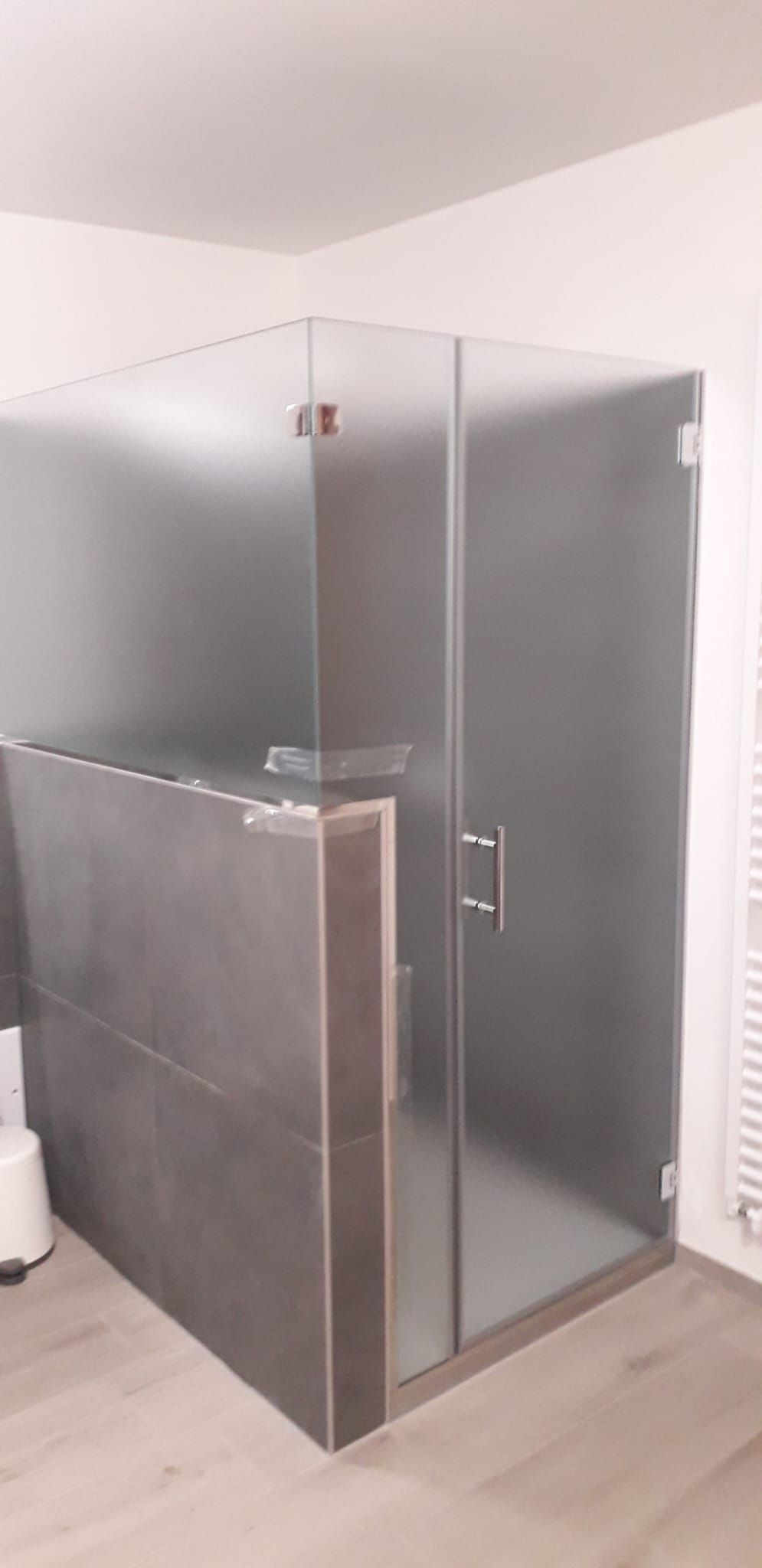 Box doccia in vetro per bagno con pannelli satinati e maniglia cromata.