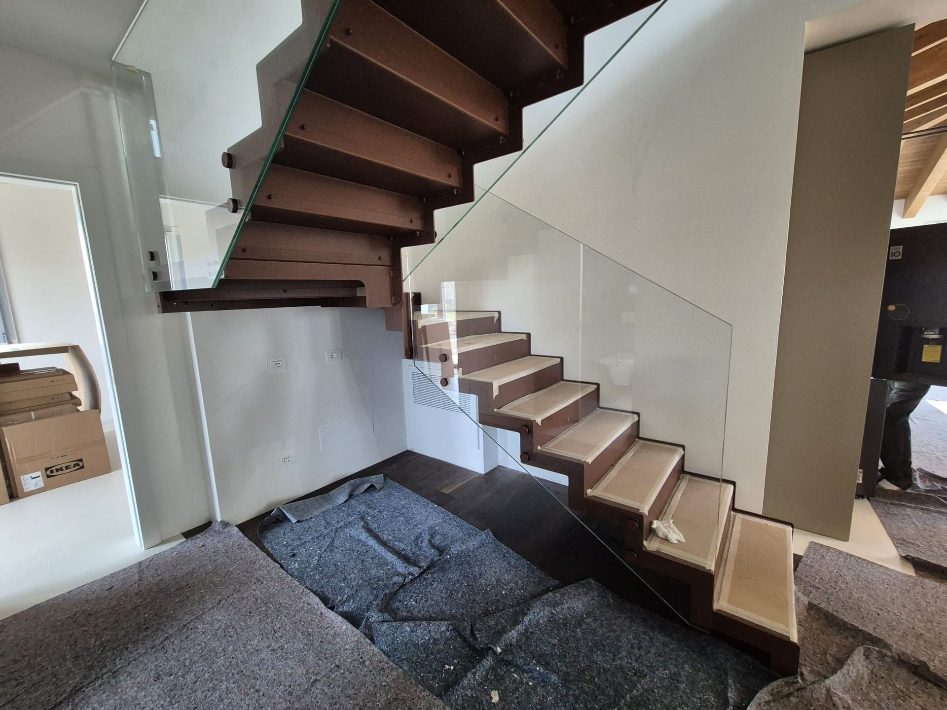 Scala a chiocciola con gradini in legno in un interno moderno, sopra un pavimento scuro