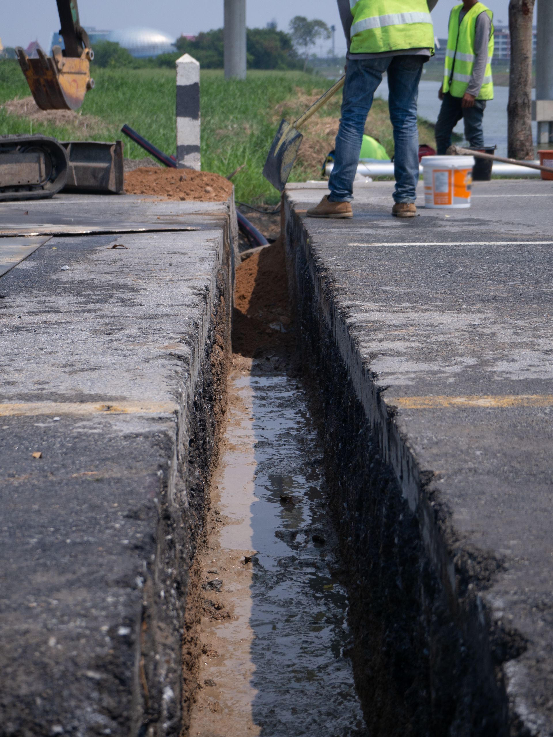 A group of construction workers are working on a road.