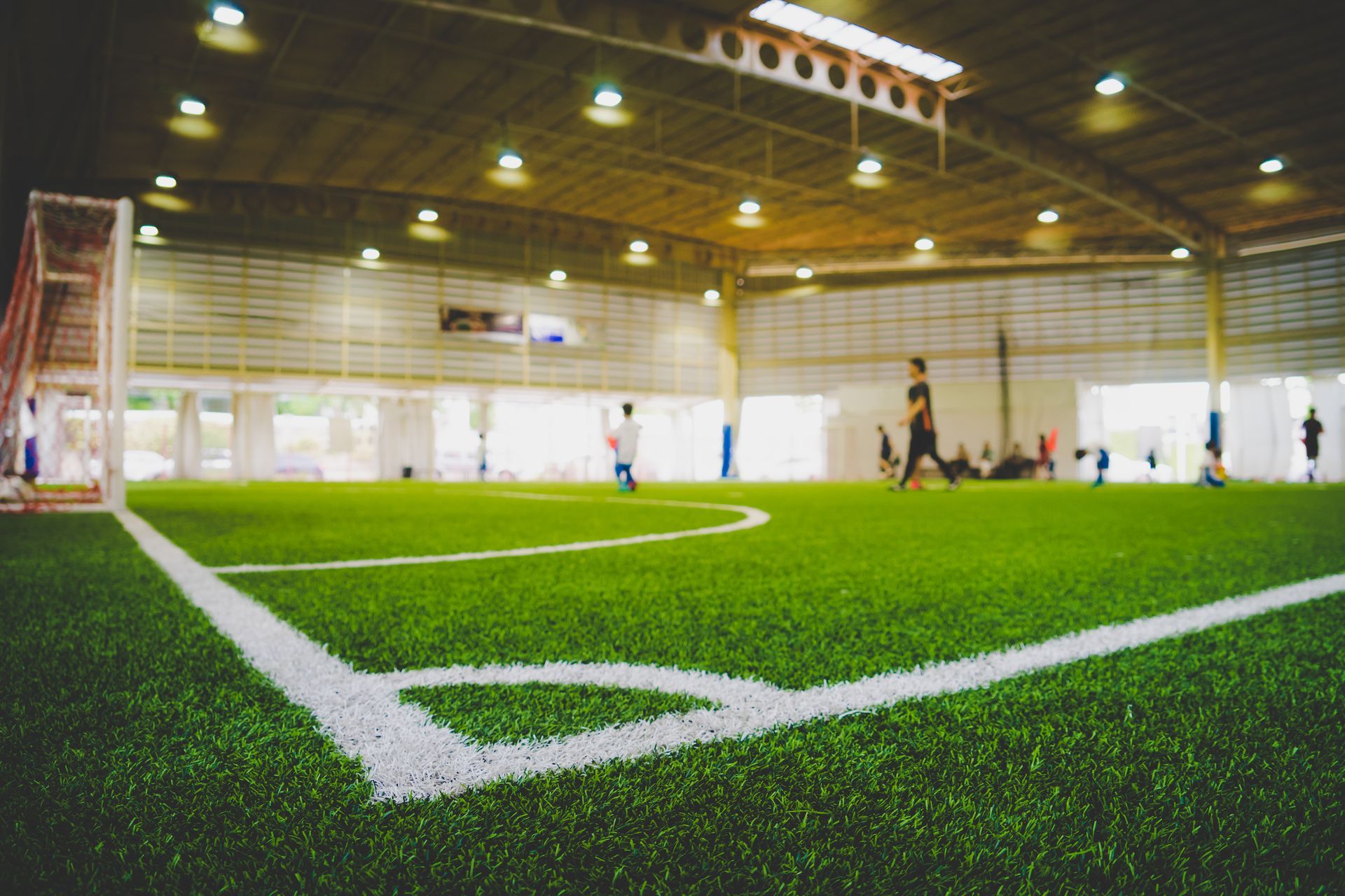 A group of people are playing soccer in an indoor stadium.