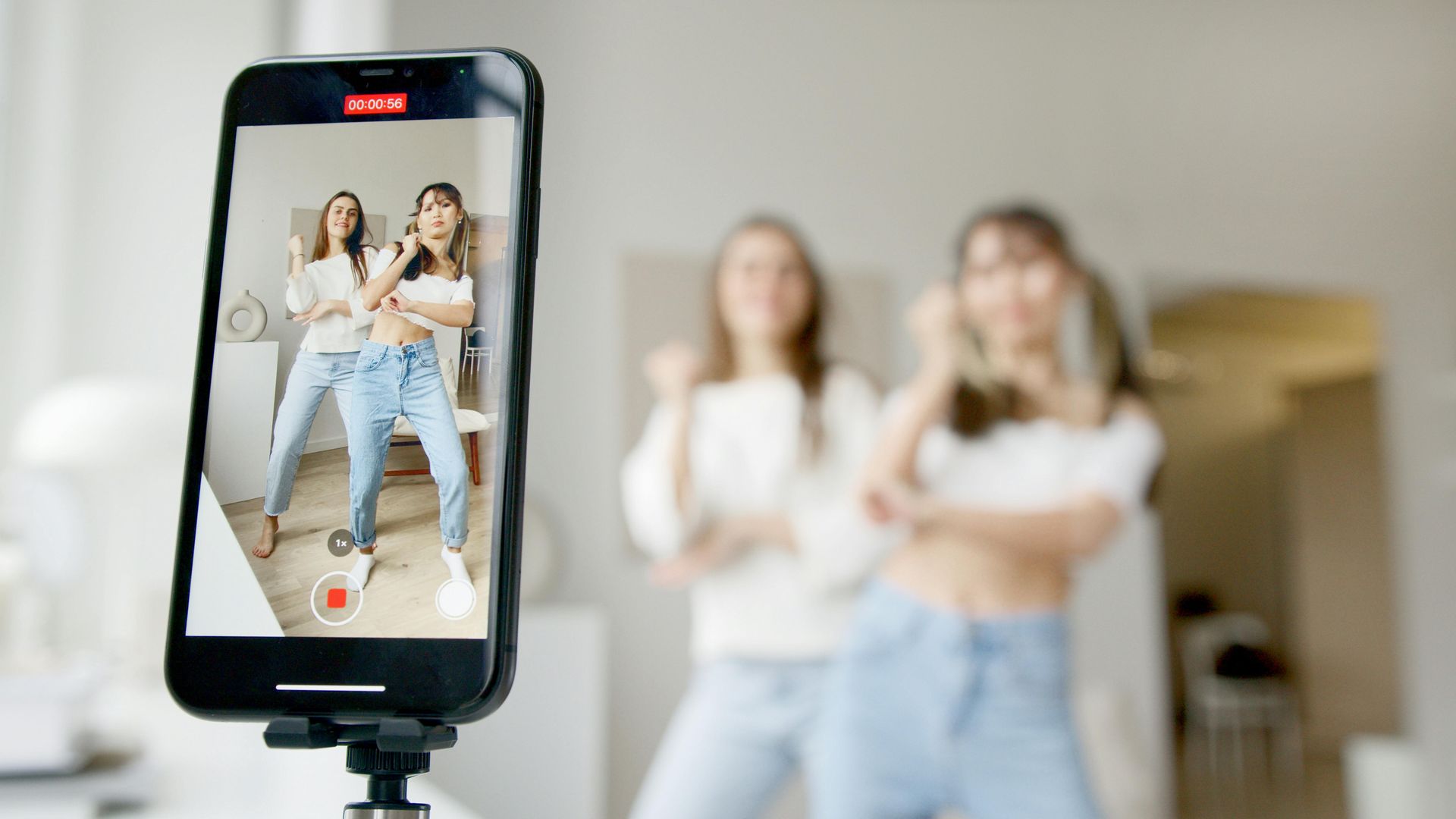 Ein Mobiltelefon nimmt ein Video von zwei tanzenden Frauen auf.
