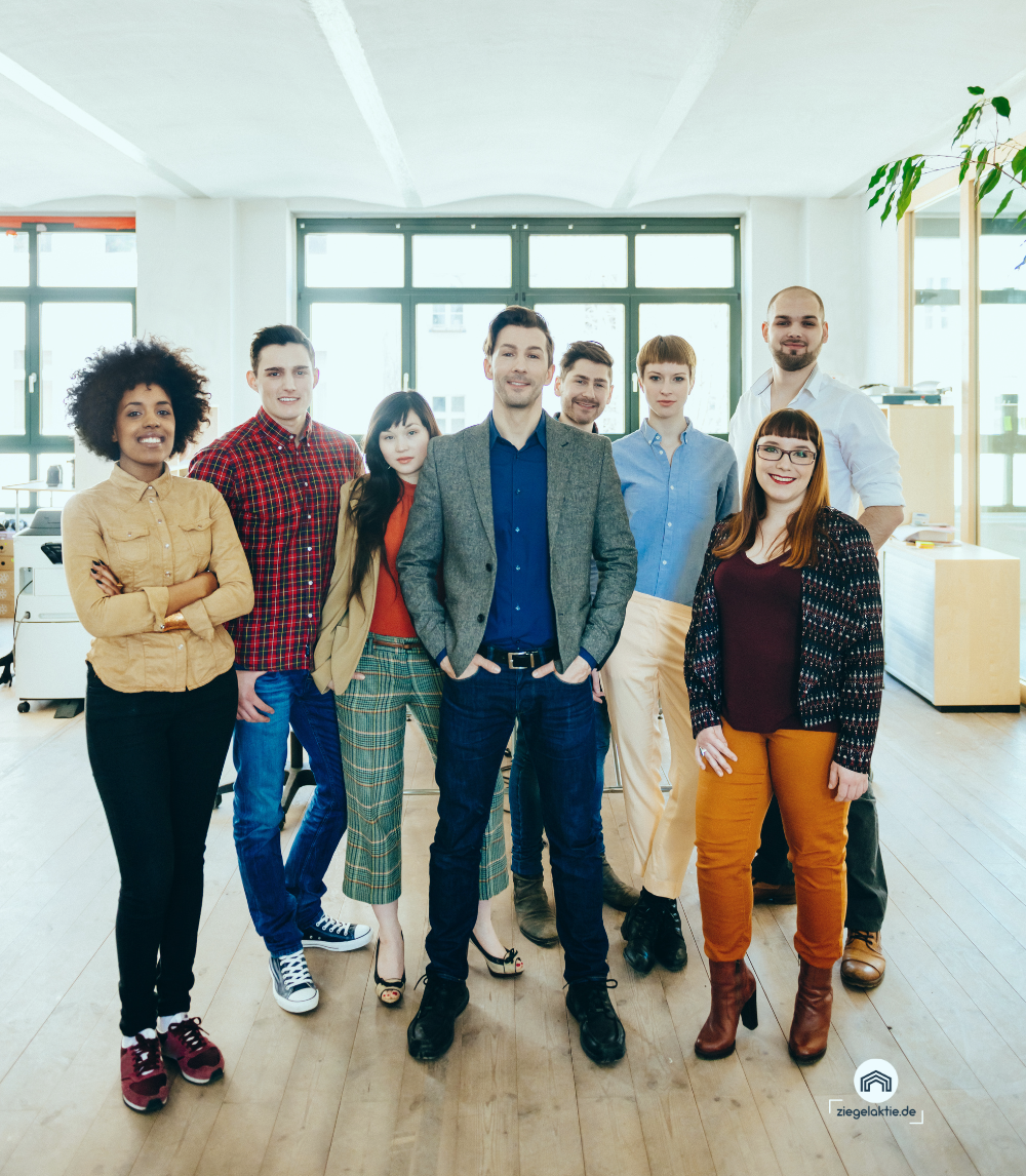 Eine Gruppe von Menschen posiert in einem Büro für ein Foto.