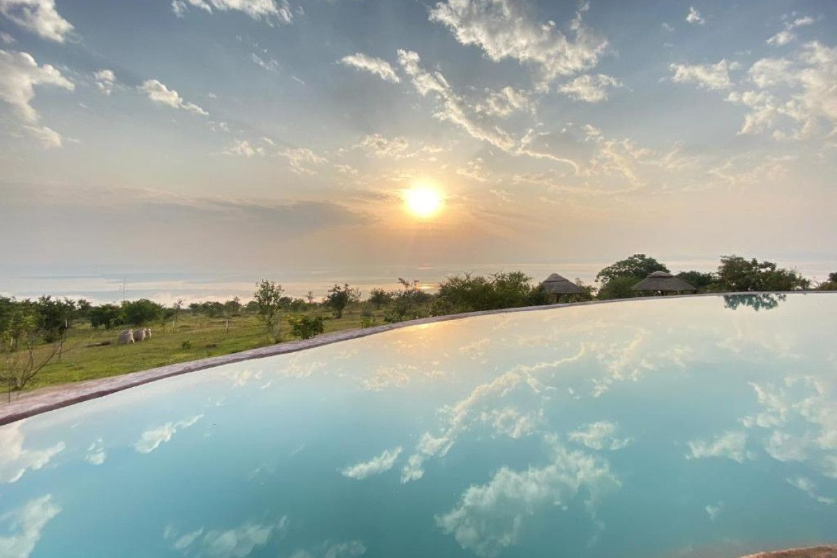 cascading pool at akagera safari camp with sunset views of lake ihema