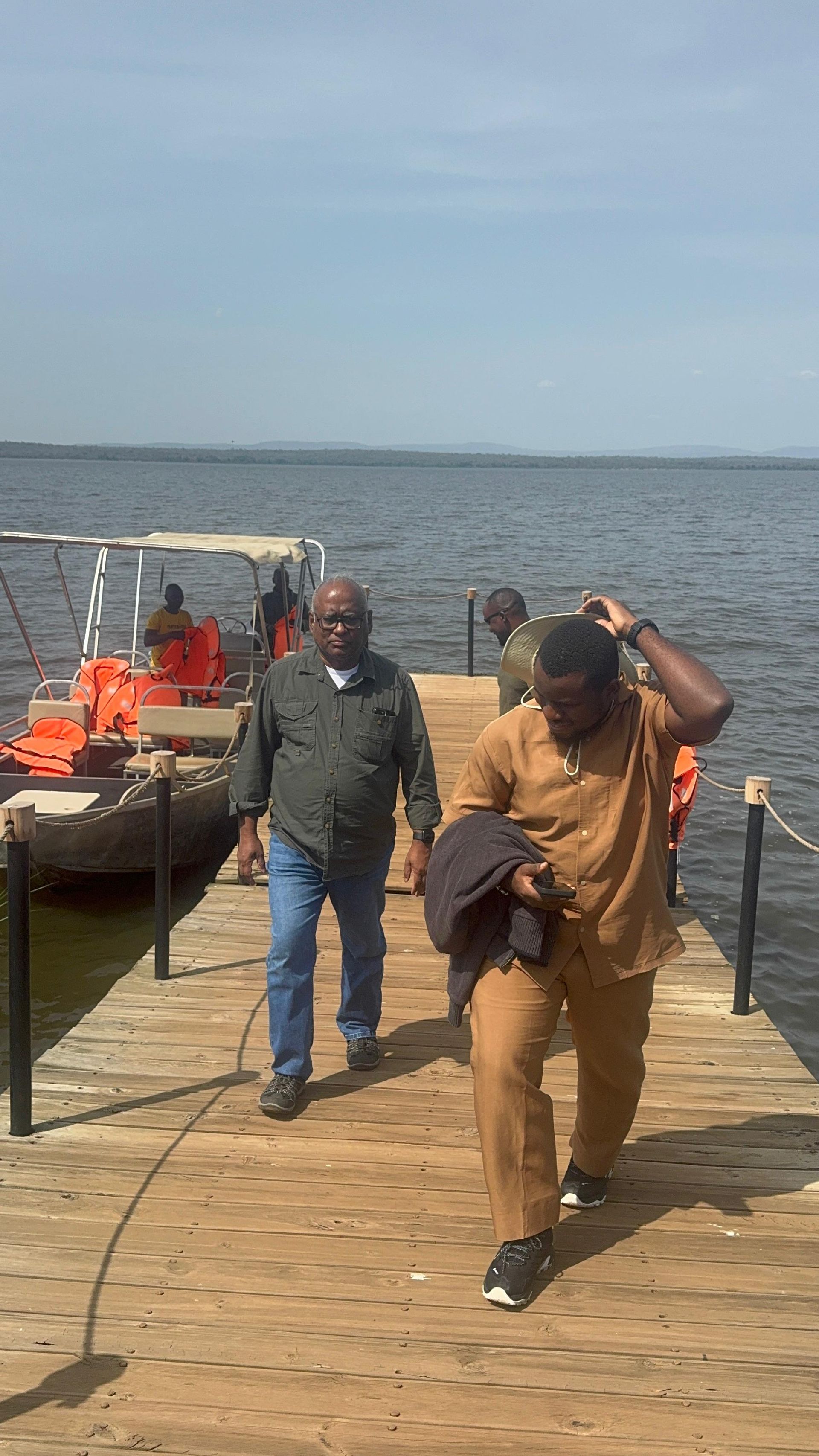 Guests walking along the wooden dock after the Lake Ihema boat safari