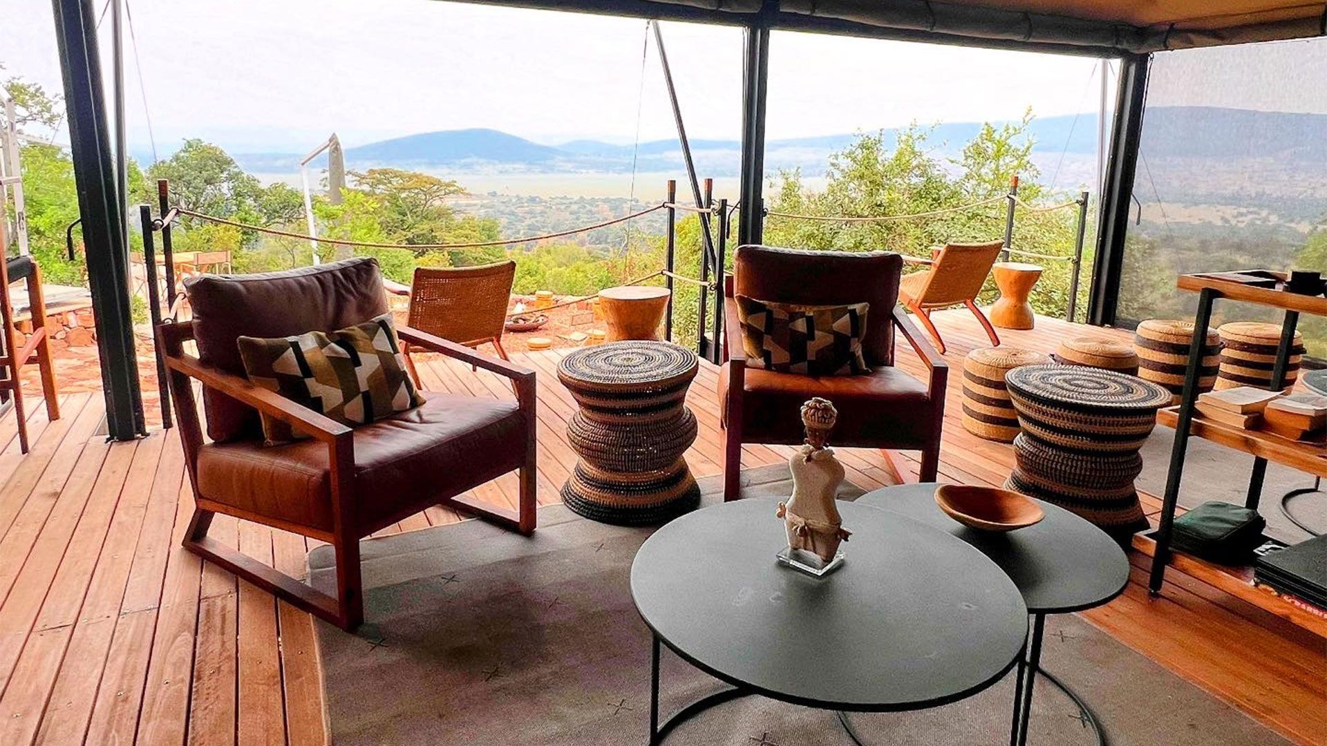 Karenge Bush Camp’s pen-air lounge deck with leather armchairs and African décor overlooking Akagera's northern plains