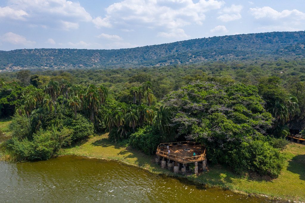Aerial view of Ruzizi Tented Lodge raised deck on Lake Ihema shoreline surrounded by palm trees and acacia woodland Akagera National Park Rwanda