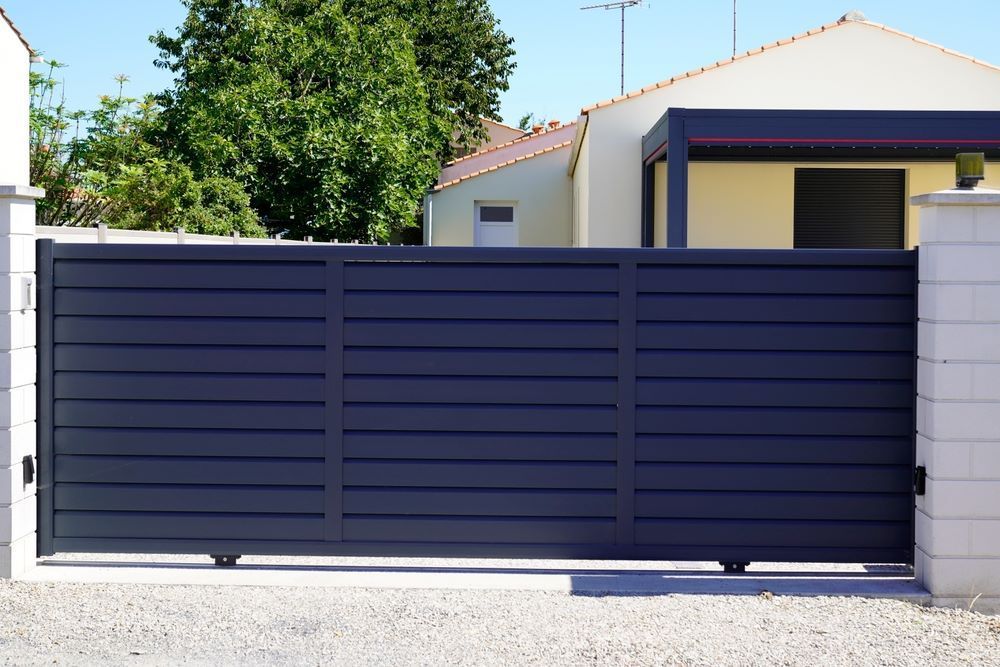 A Black Sliding Gate in Front of a House — Airlie Beach Garage Doors In Cannonvale, QLD