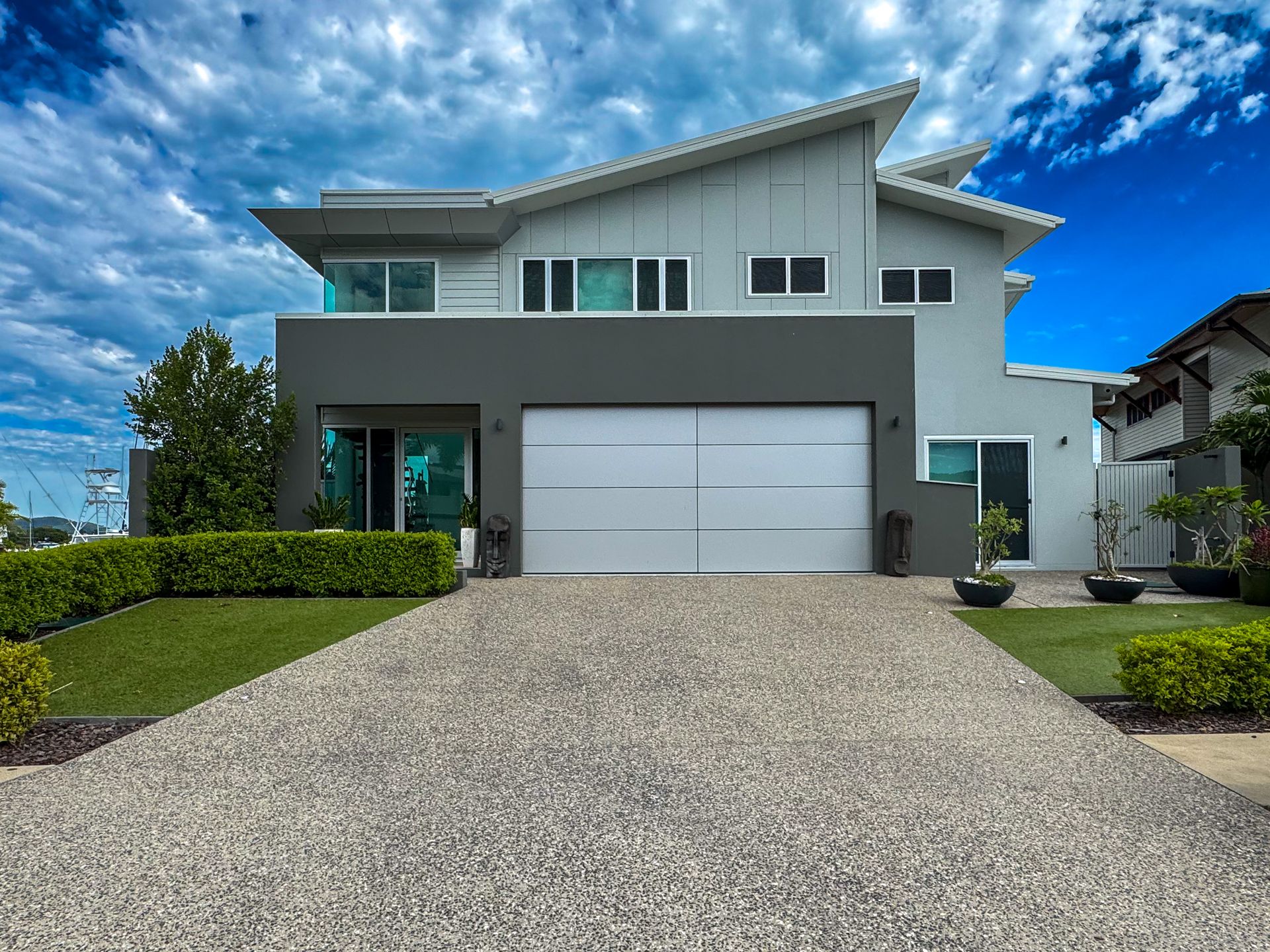 A Large White Brick House With a Double Garage Door — Airlie Beach Garage Doors In Airlie Beach, QLD