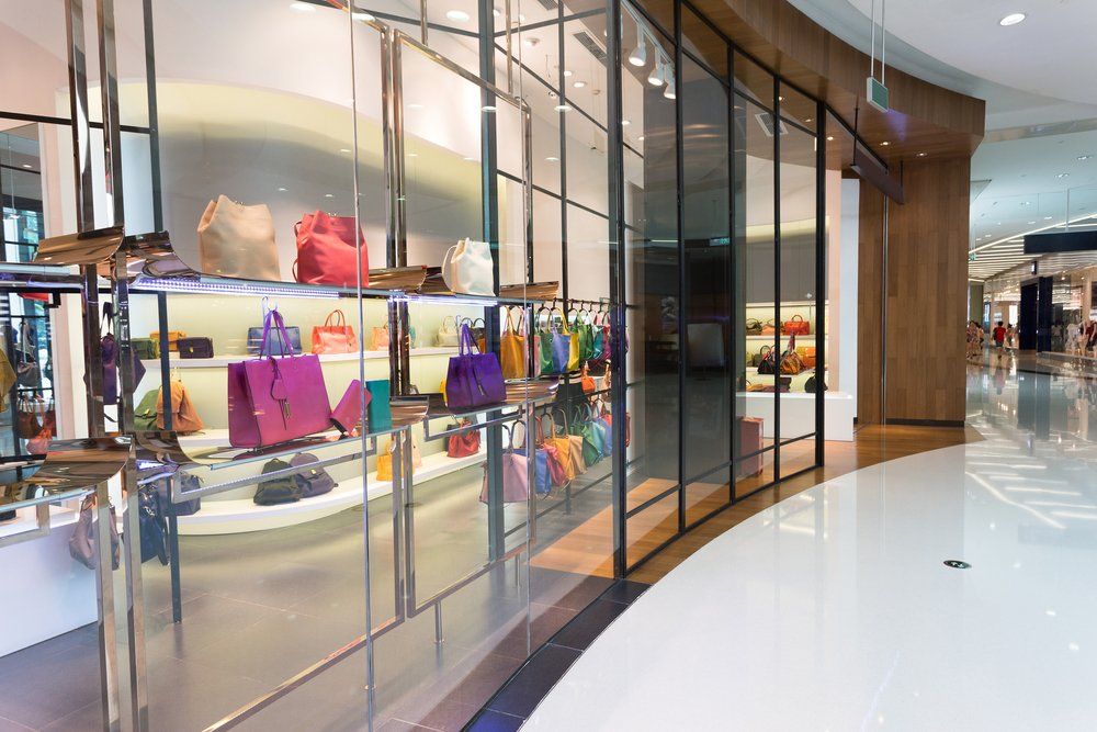 A store with a lot of handbags on display in a mall.