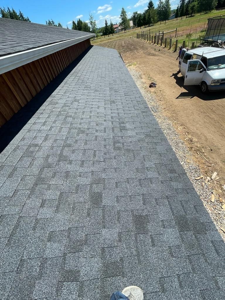 New roofing project, gray asphalt shingle roof on a building.
