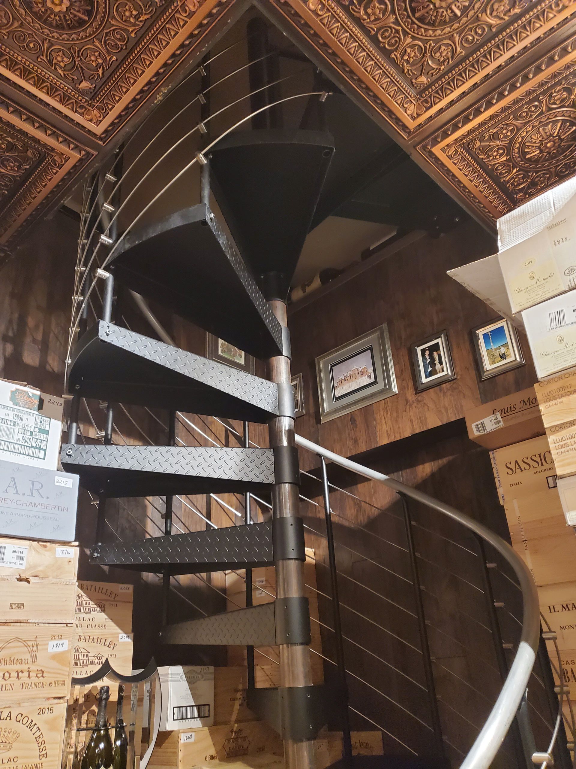 A spiral staircase in a room with boxes on the floor.