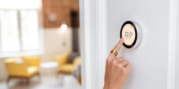Hand knocking on a white room service door with a gold handle and number plate