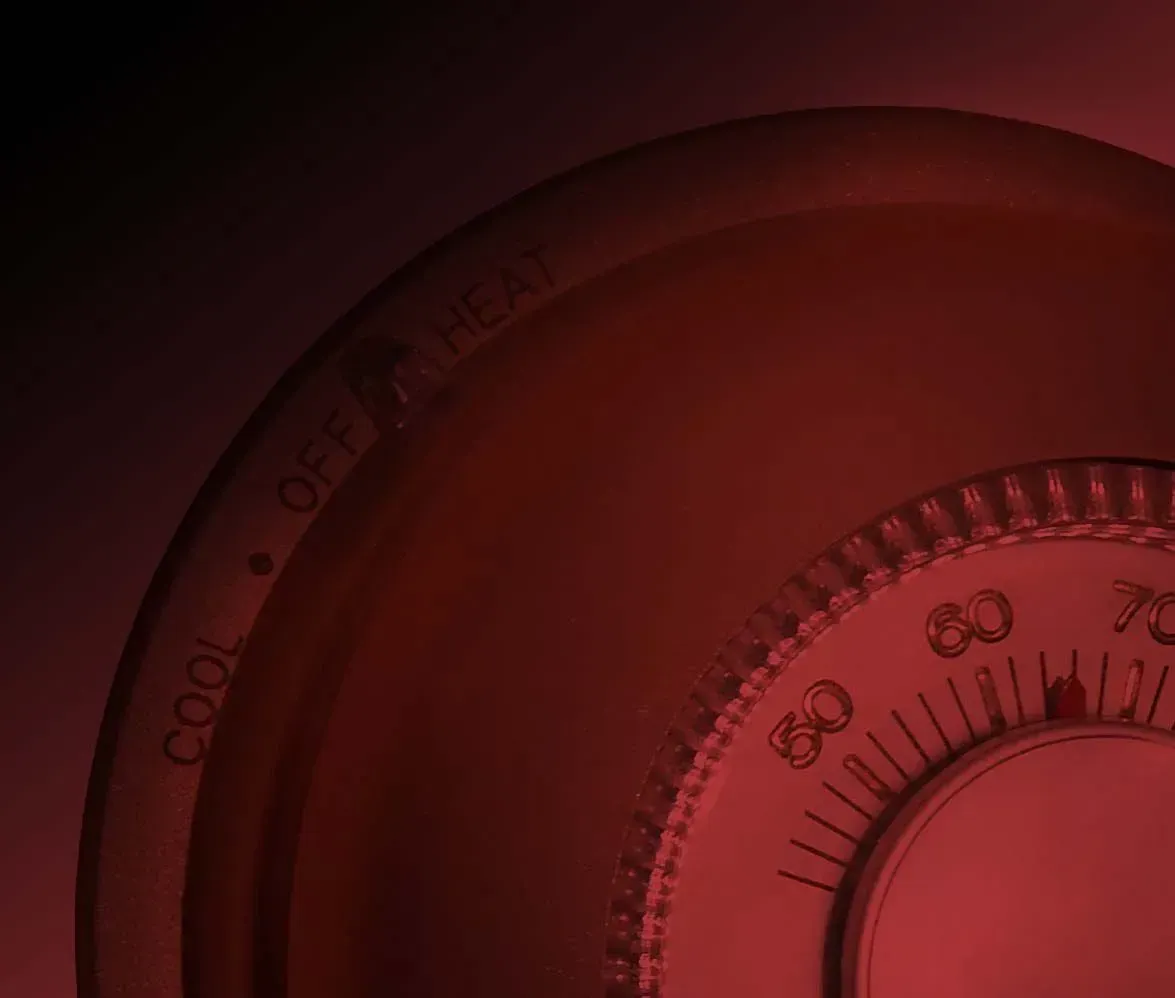 Close-up of a red circular dial with black markings and numbers on a dark background