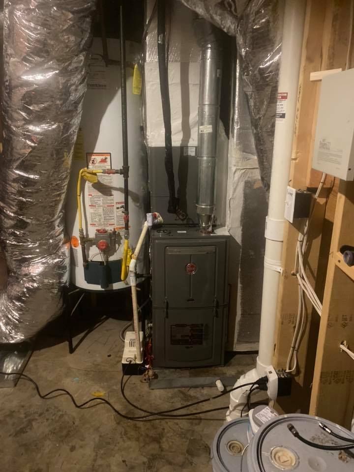 Basement furnace and HVAC equipment with exposed ducts, electrical wires, and storage boxes nearby