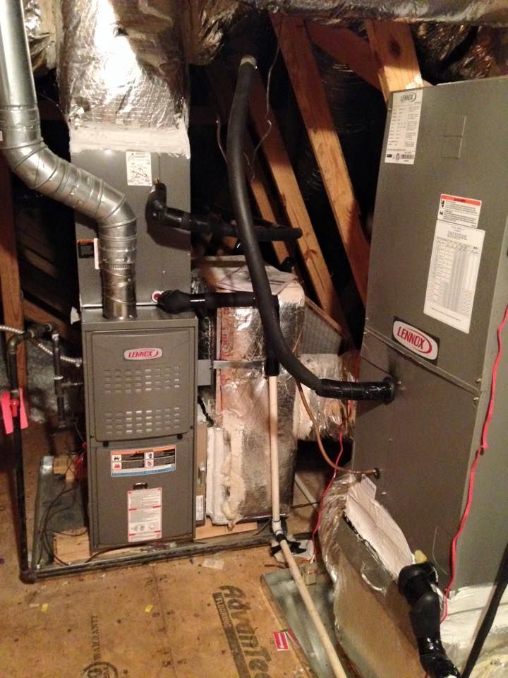 Basement with furnace, ductwork, and exposed pipes against unfinished walls