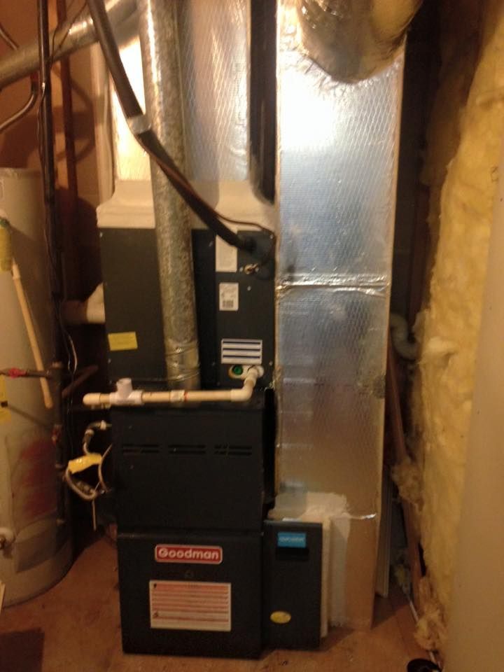 Gas furnace and HVAC ductwork in a narrow unfinished basement utility area