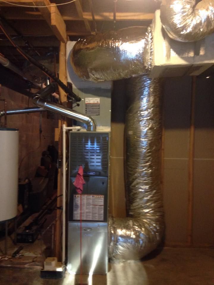 Basement with HVAC ductwork and furnace unit in a utility area