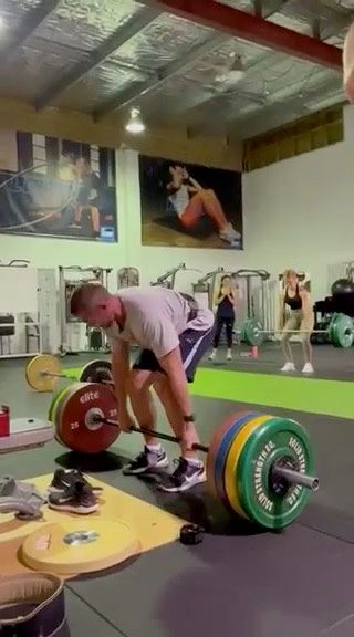 Ray man is lifting a barbell in a gym