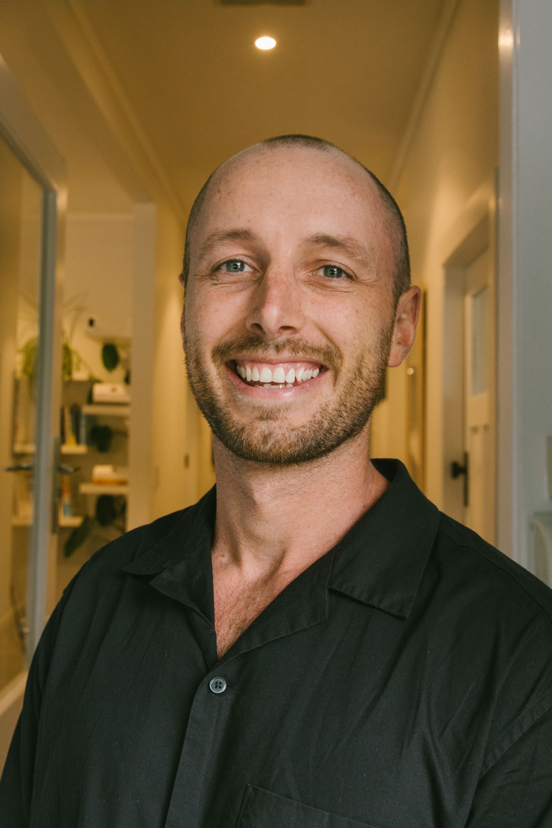 Hayes from Orewa Chiropractic in a white shirt is smiling for the camera.