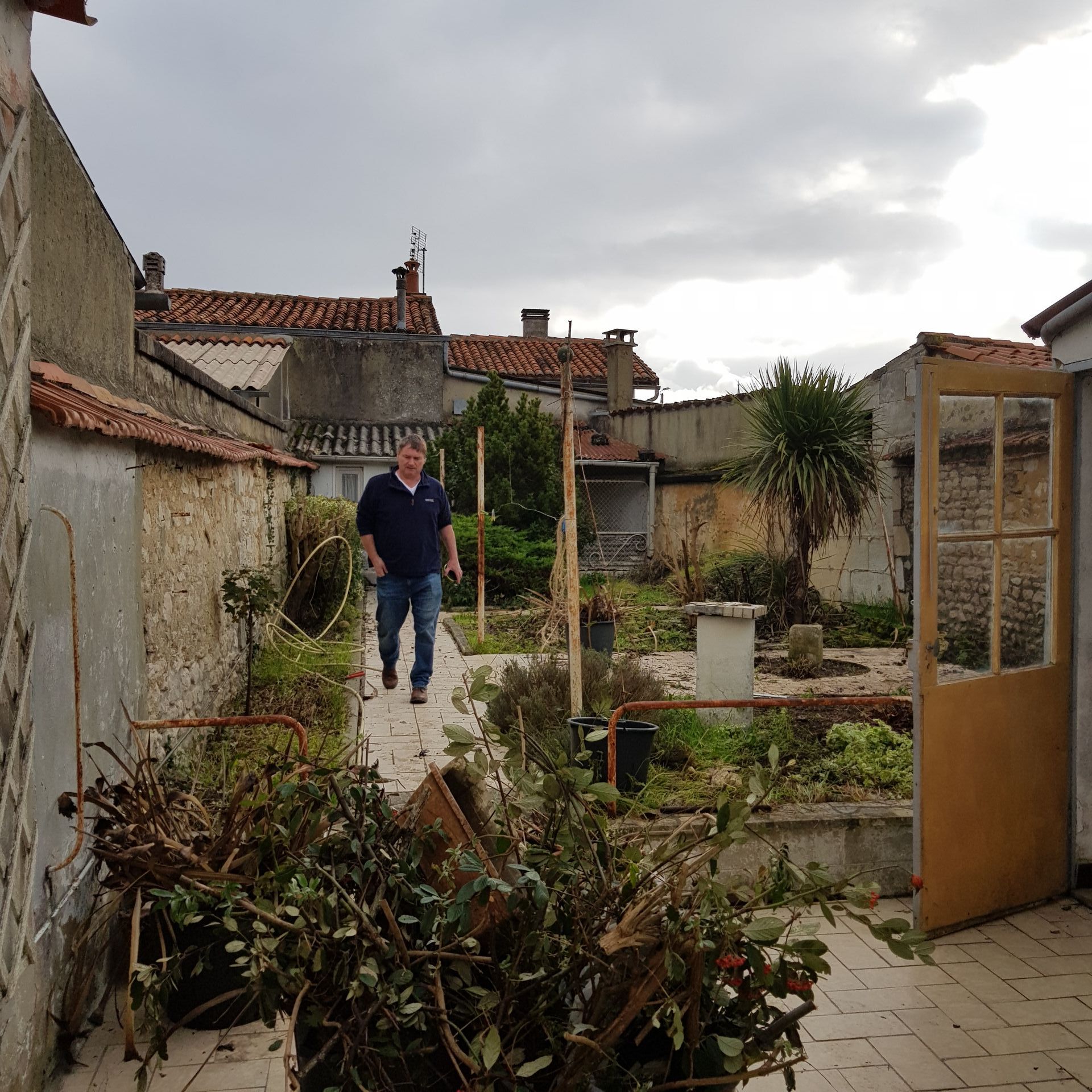 garden before renovation with weeds and rubbish