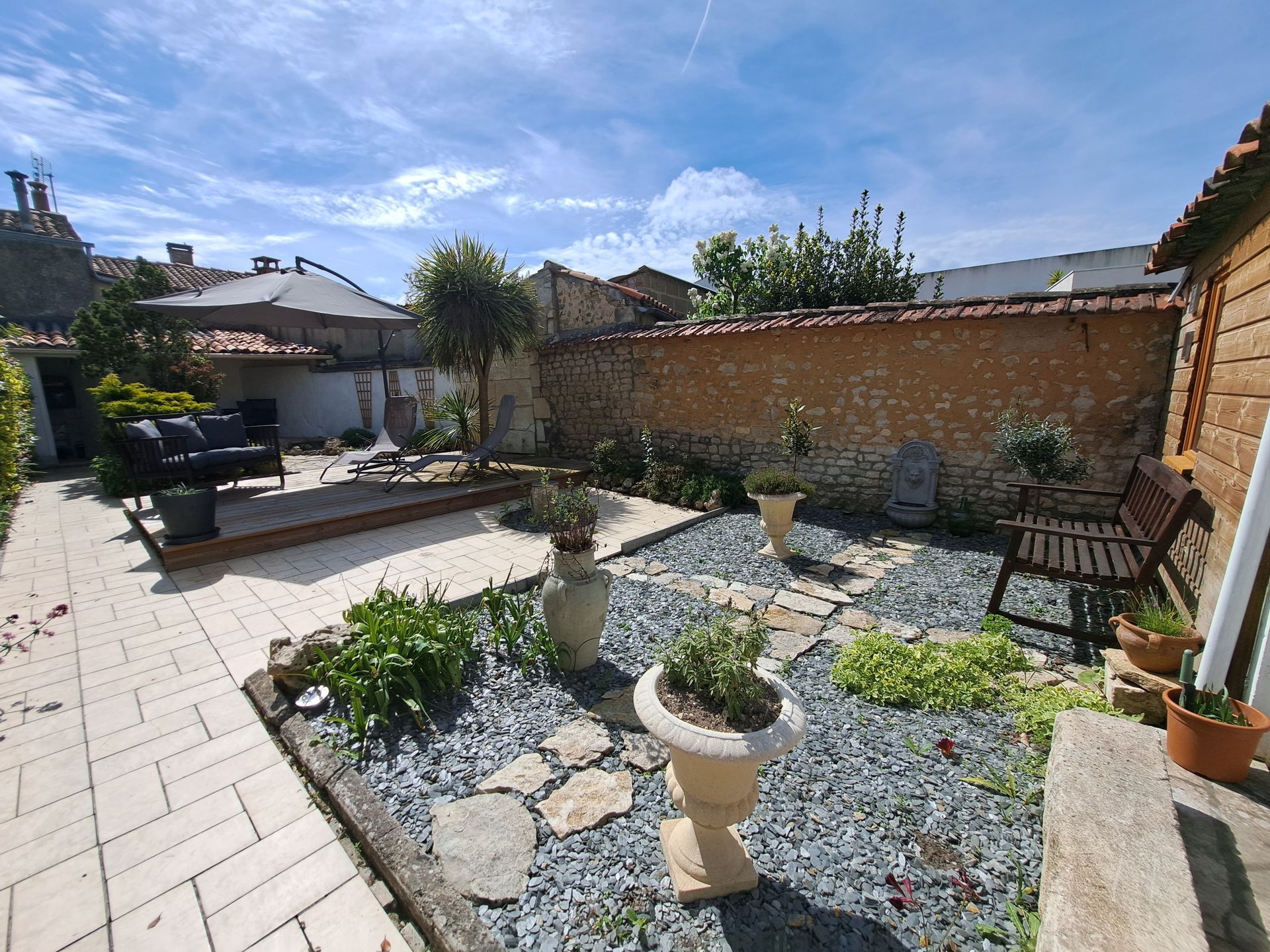 Romanesque garden with tiled walkways, slate chips and ornate herb pots