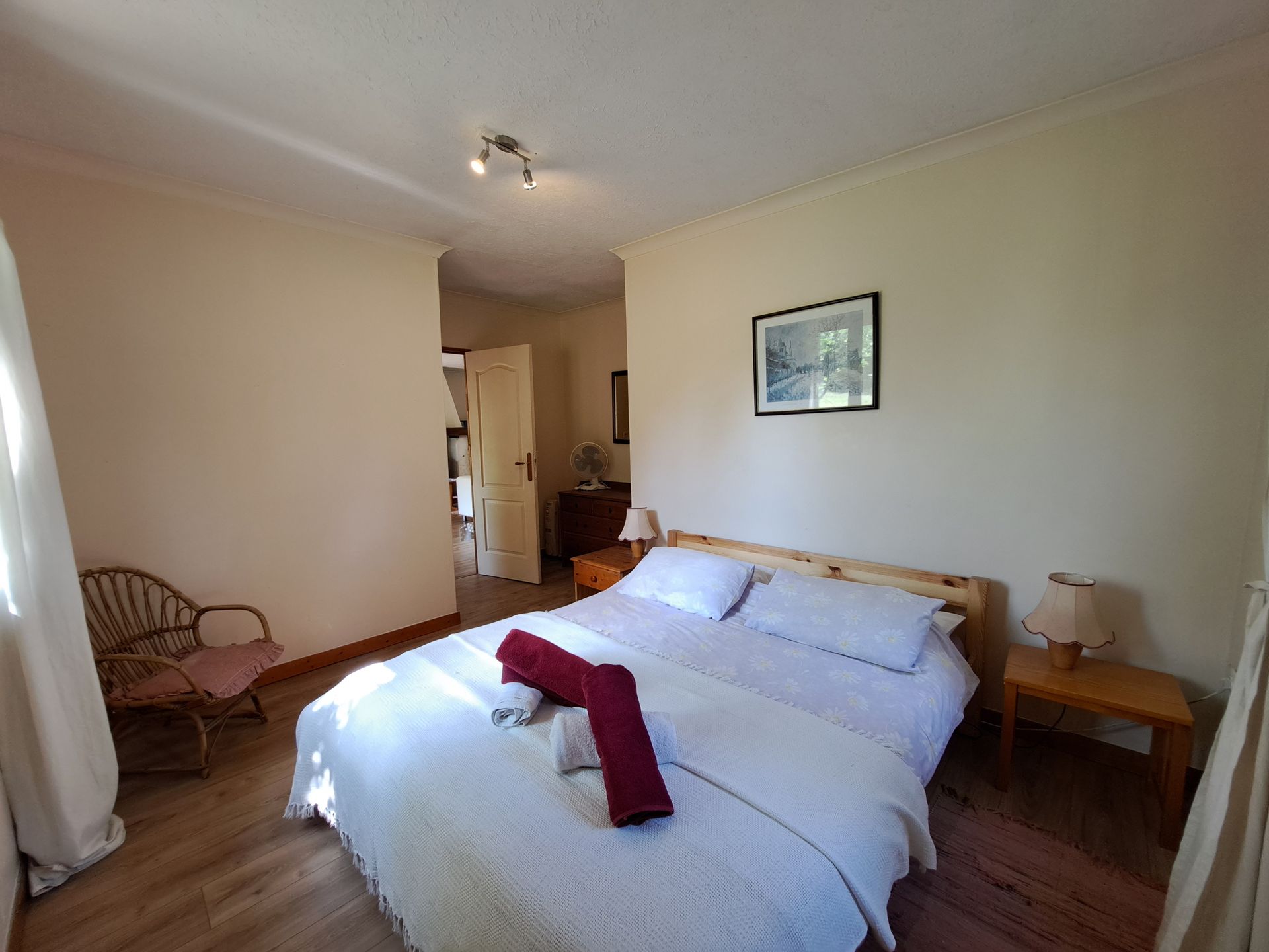 double pine bed in a bedroom with cream walls and wood effect laminate flooring