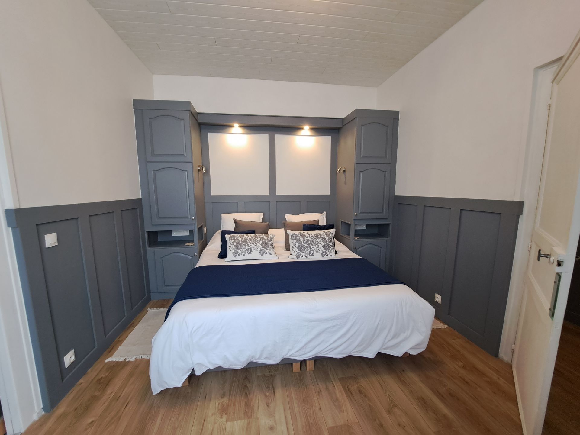 king sized bed with white cotton linen and blue throw