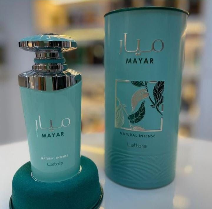 Frasco de perfume rojo “Mayar Cherry Intense” con acentos dorados, en caja cilíndrica roja.