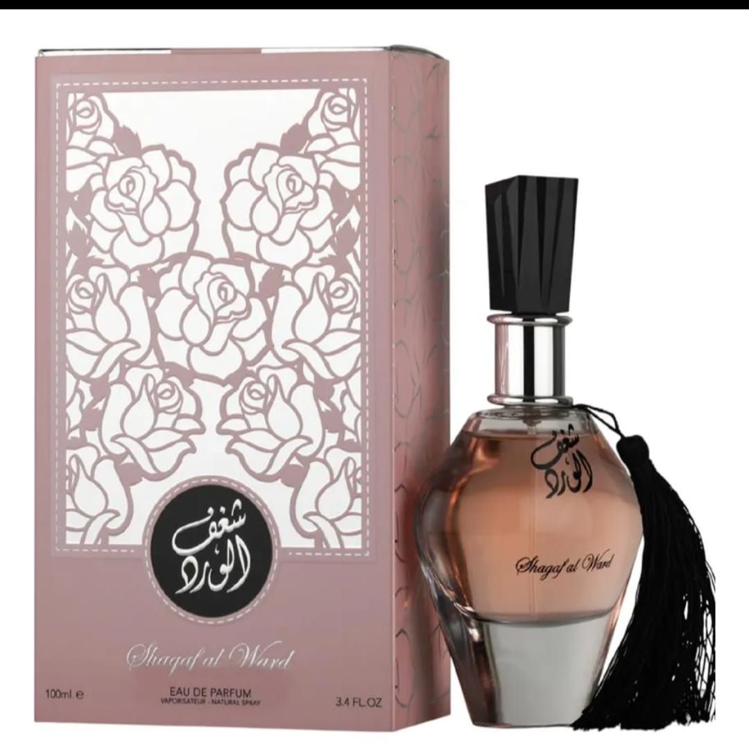 Frasco de perfume floral rosa junto a una caja decorativa a juego con un adorno de borla negra.