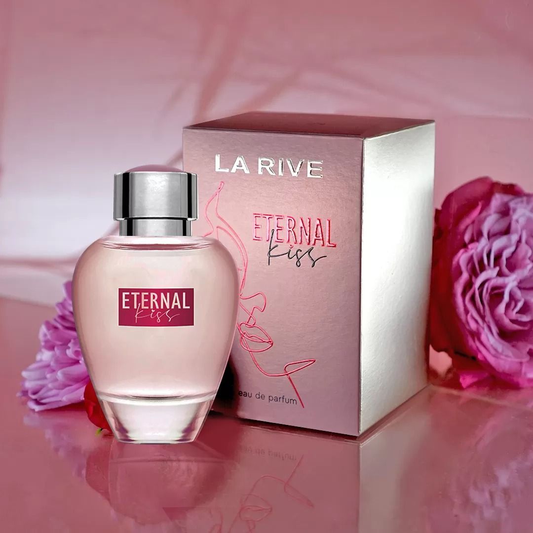 Frasco y caja del perfume La Rive Eternal Kiss sobre fondo rosa con detalles de rosas.