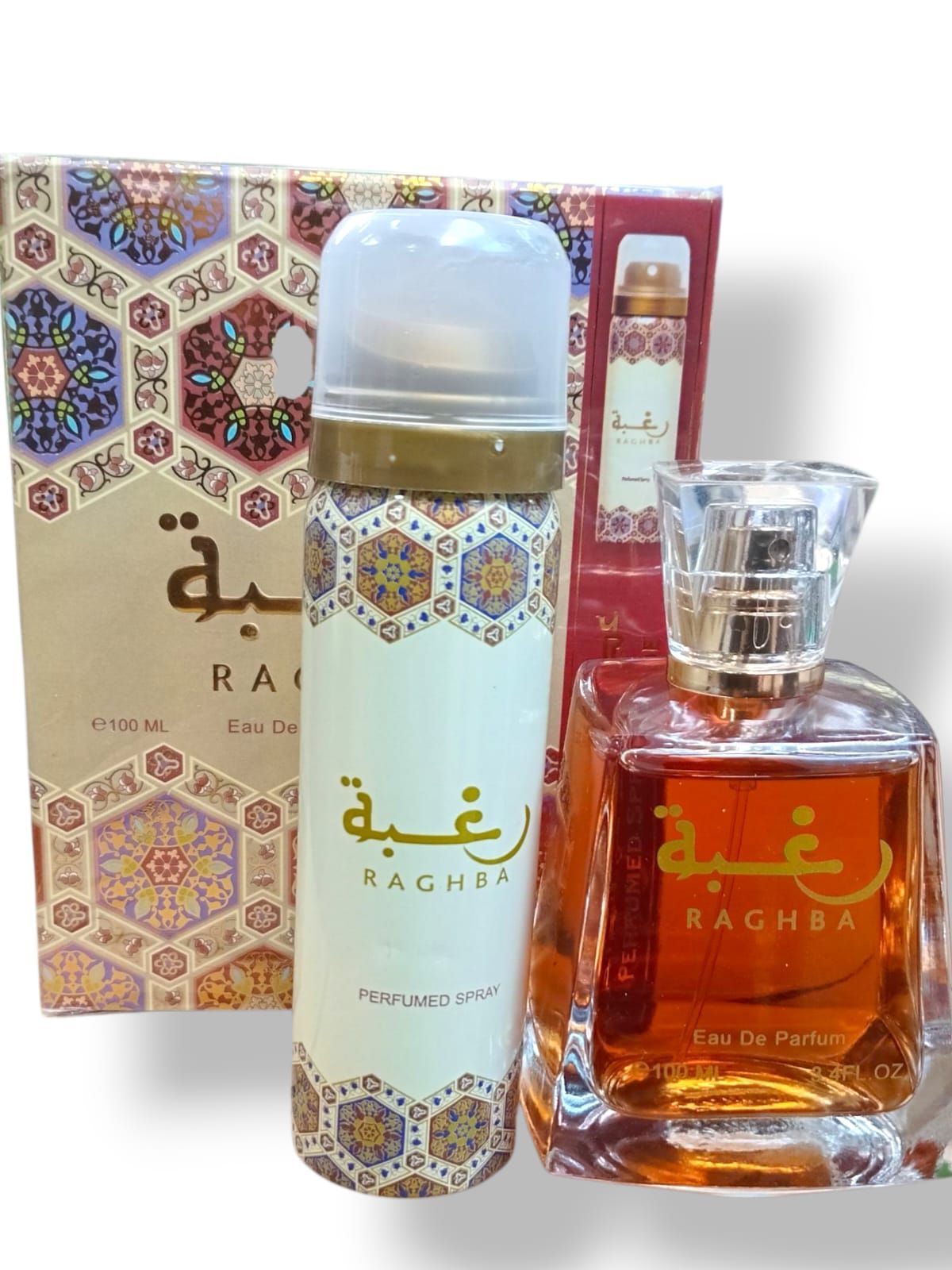 Set de perfume de lujo con frasco ámbar, spray corporal blanco y envase estampado en dorado y rojo.
