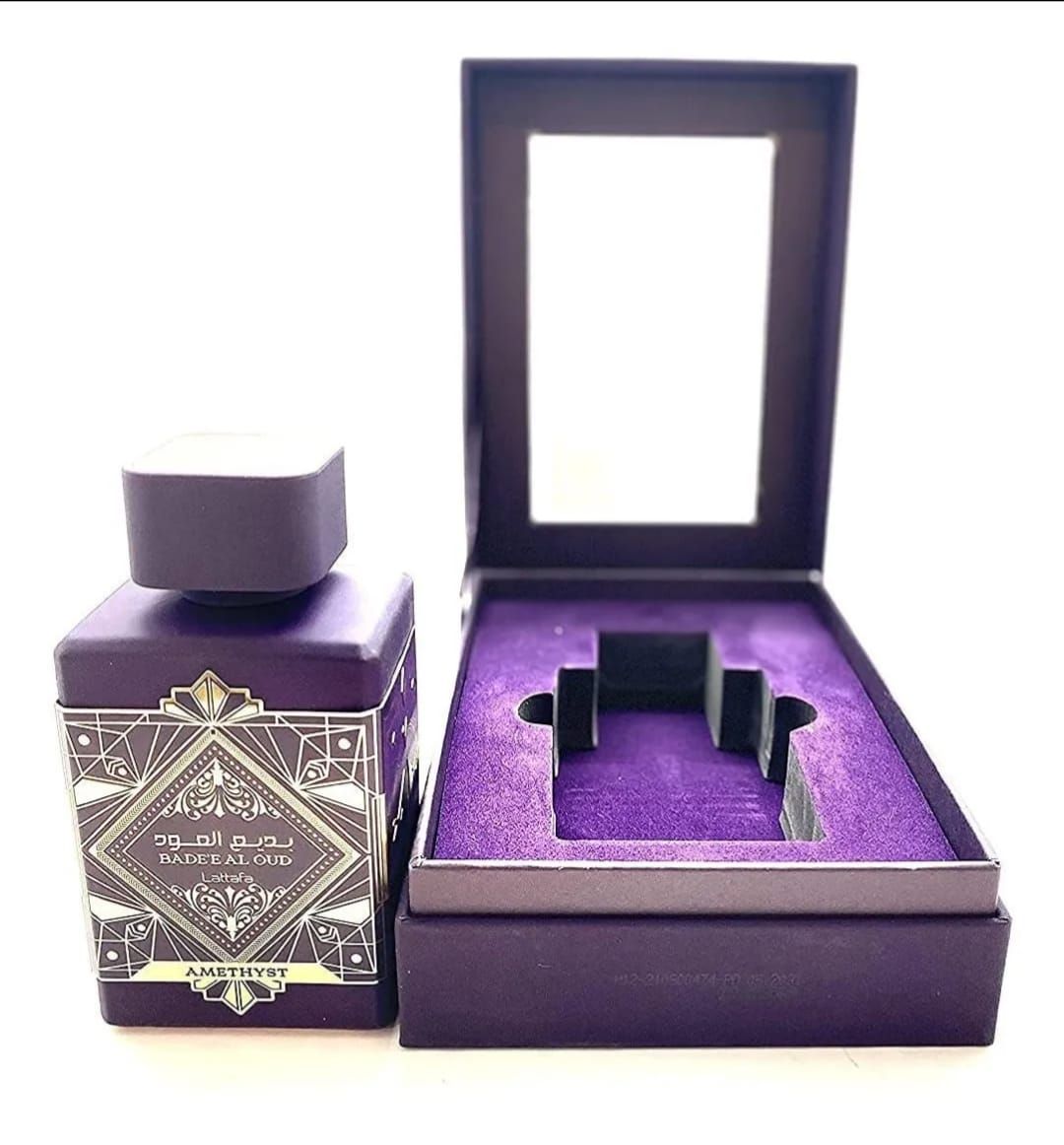 Cajas de perfume de lujo color púrpura y expositor de frascos con embalaje ornamentado y bandeja de presentación abierta.