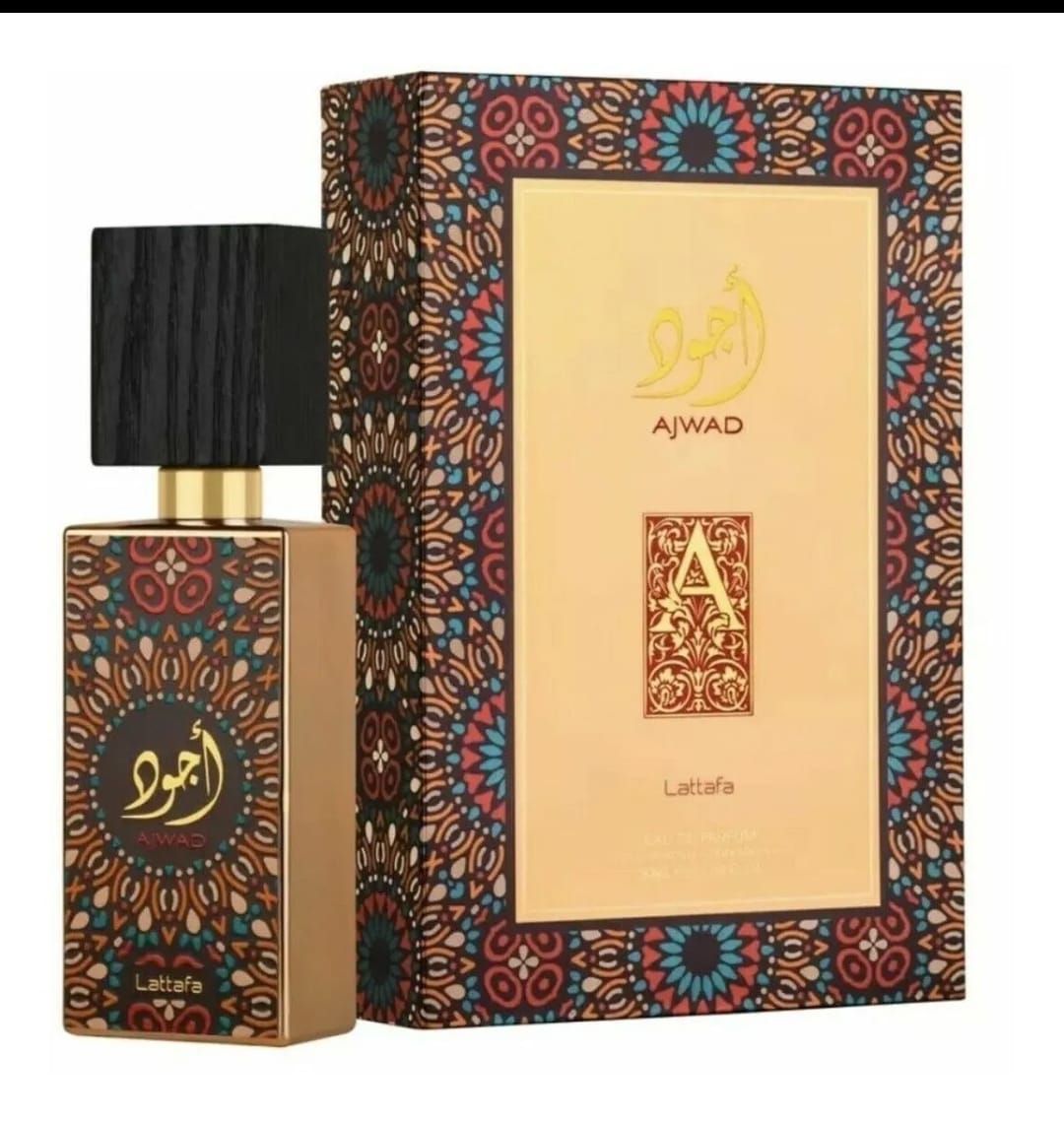 Frasco de perfume color ámbar con tapón negro junto a una caja floral ornamentada sobre un fondo blanco.