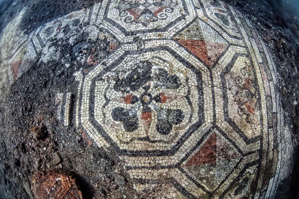 Weathered stone with a geometric mosaic pattern in gray, white, and rust red
