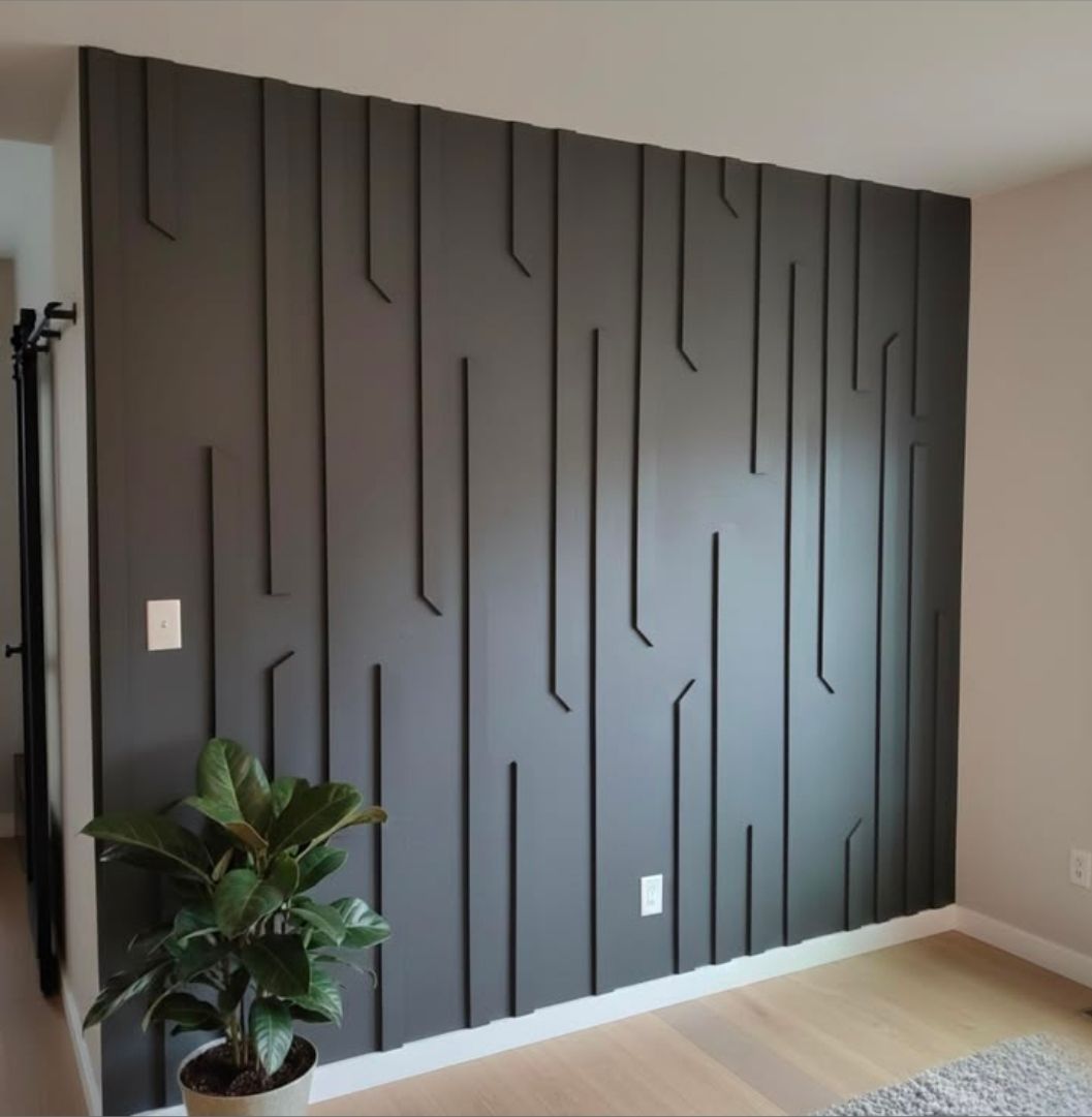 Modern room with a dark gray accent wall of vertical slats and a potted plant on the left.