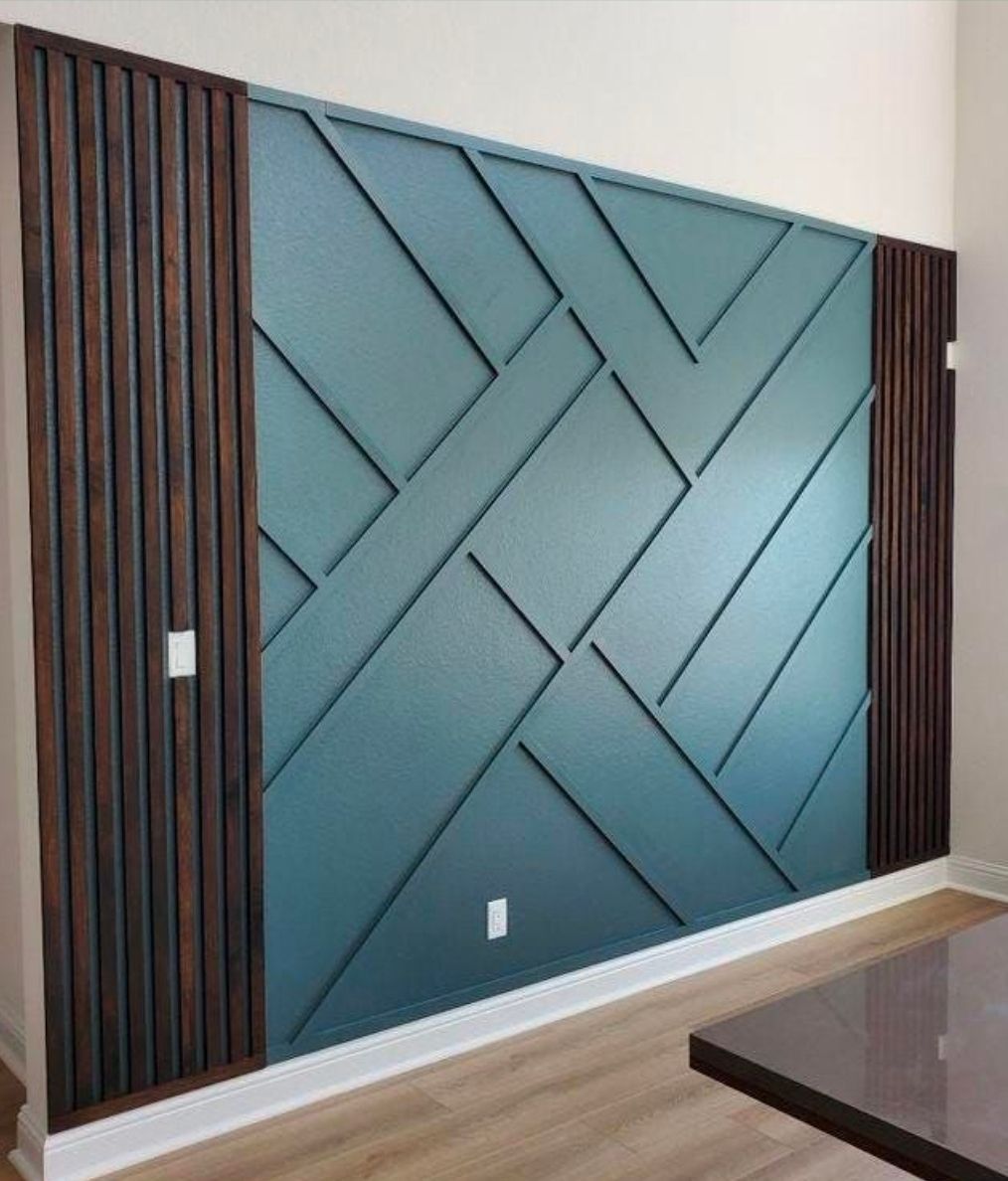 Geometric blue accent wall with diagonal panels, flanked by dark wood slat columns in a modern room
