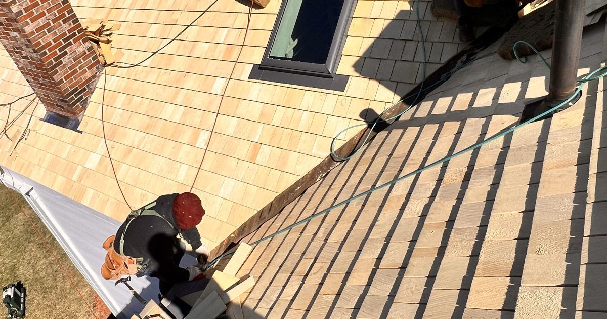 worker on top of a roof fixing it