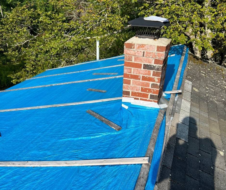 A brick chimney on top of a blue tarp