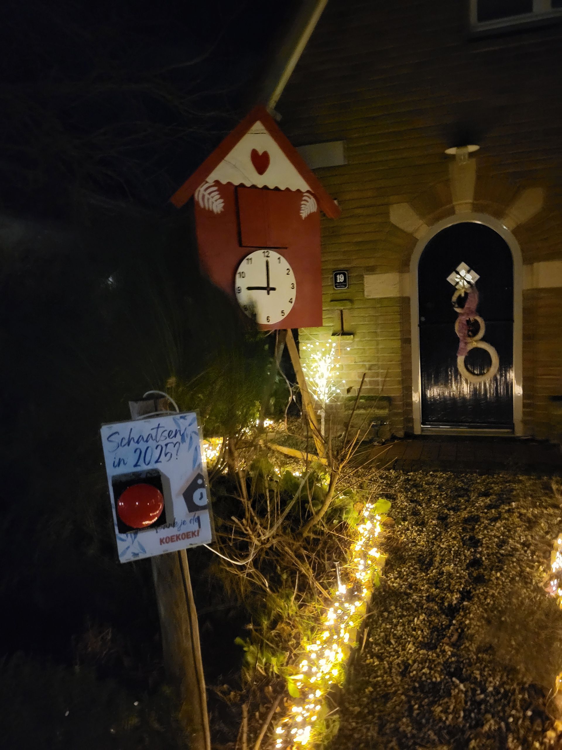 Rode koekoeksklok met een grote rode knop, verlicht de tuin 's nachts.