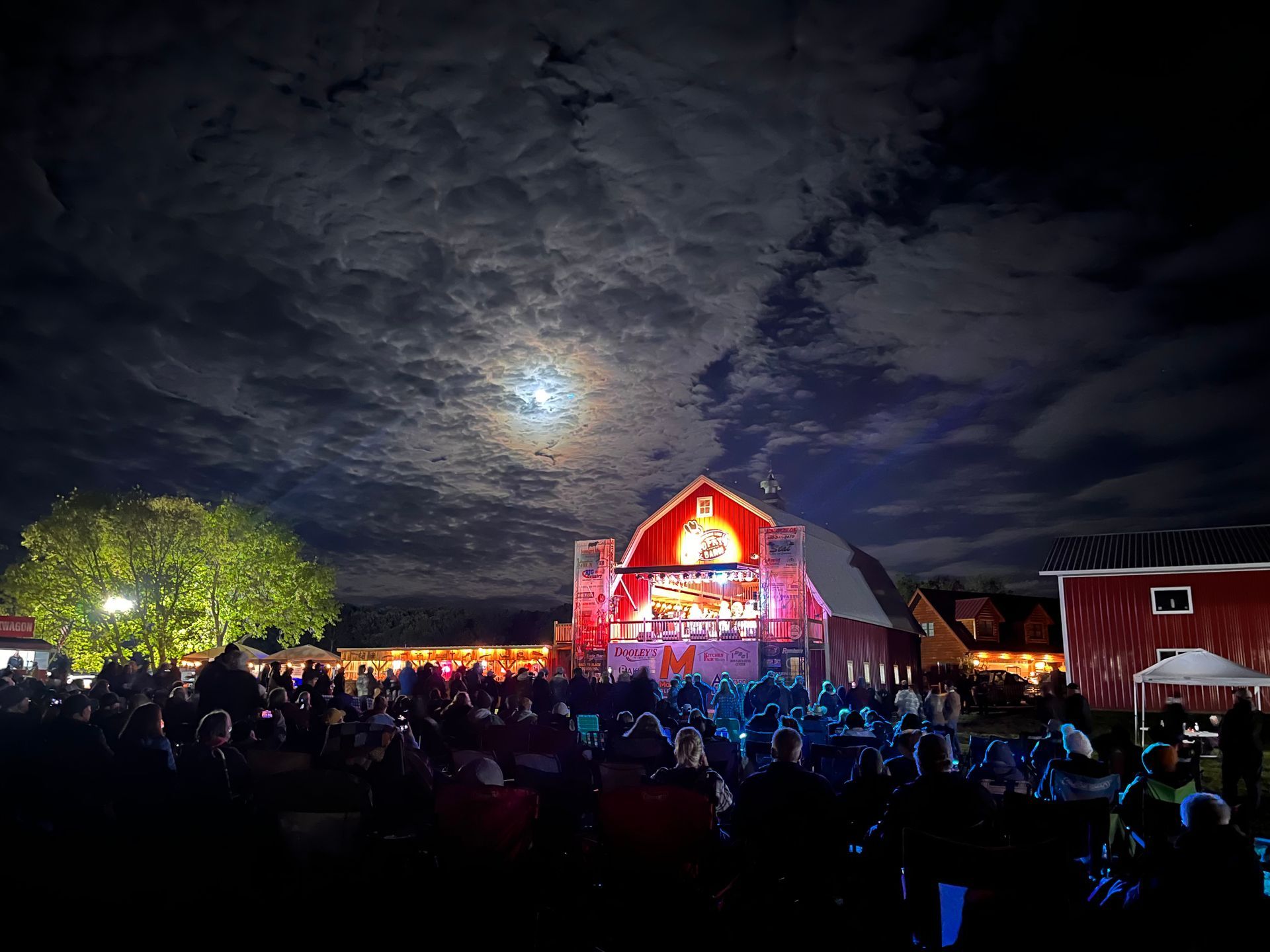 An aerial view of a red barn with a stage inside of it at night.