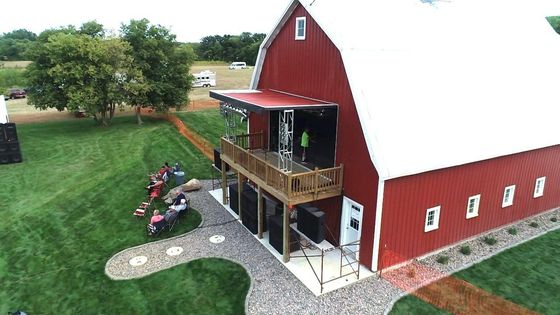An aerial view of a red barn with a balcony.