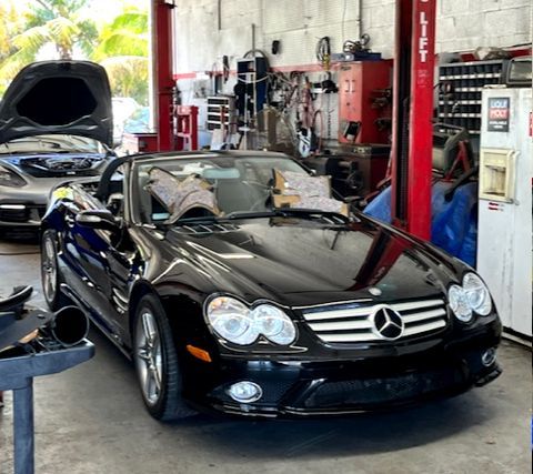 A black car is on a lift in a garage