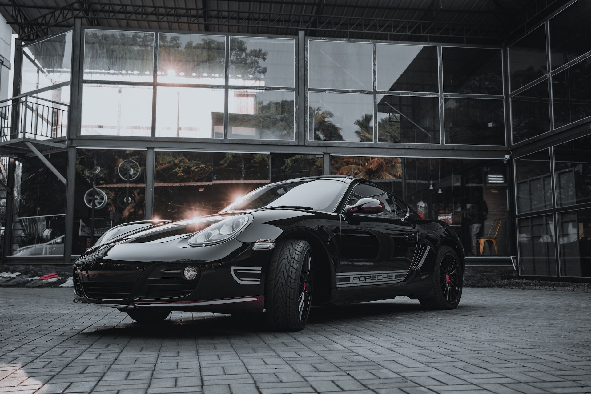 A black sports car is parked in front of a building.